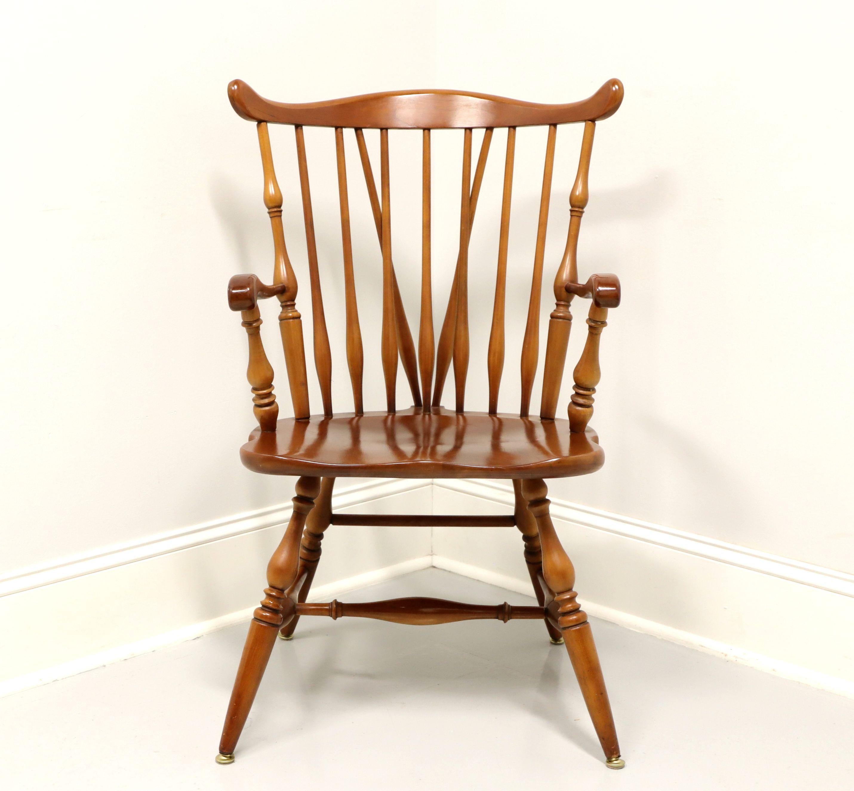 A Windsor style dining armchair by Ethan Allen, their Duxbury. Solid maple, fiddleback with turned side spindles, curved arms with turned spindle supports, saddle shape seat, tail-supports with spindles, turned legs and stretchers. Made in the USA,