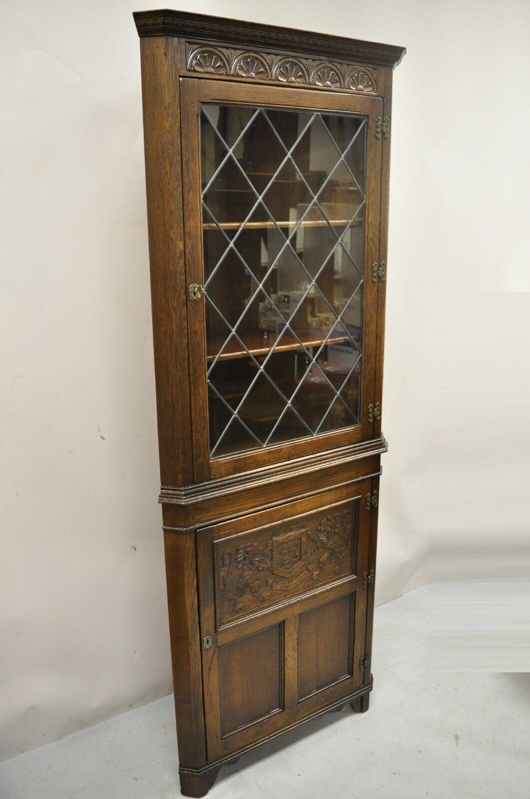 Ethan Allen England Royal Charter oak Sussex Jacobean Curio corner cabinet. Item features leaded glass door, carved door panel with lions and shield, solid wood construction, beautiful wood grain, distressed finish, nicely carved details, 2 swing