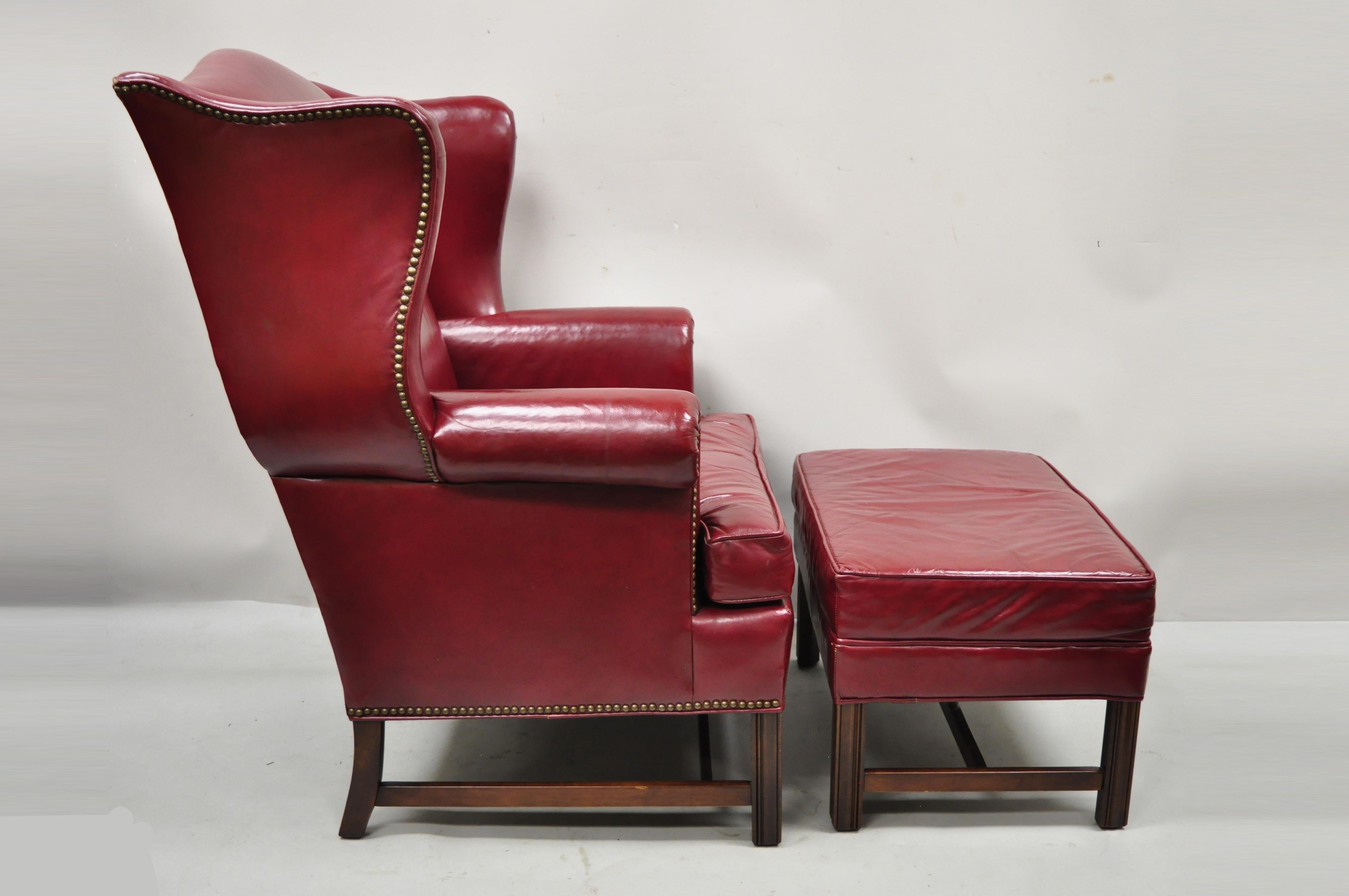 Vintage Ethan Allen English Georgian Burgundy red leather wingback lounge chair and ottoman. Item features high quality top Georgian leather upholstery, shapely wingback, stretcher base, nailhead trim, heavy solid wood construction, original label,
