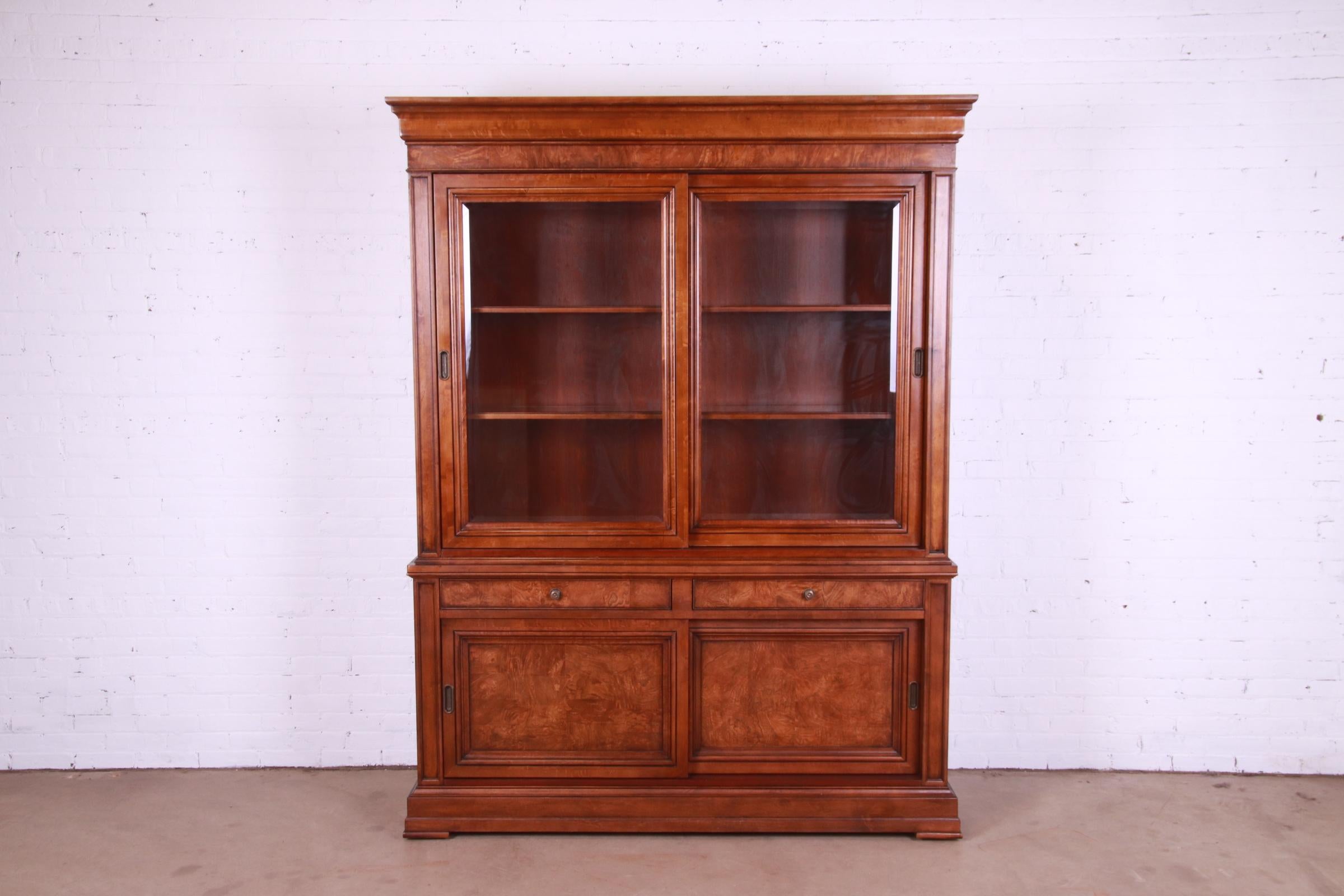 A gorgeous French Louis Philippe style two-piece lighted breakfront bookcase or display cabinet

By Ethan Allen

Circa 1990s

Burl and cherry wood, with glass front doors and original brass hardware.

Measures: 67