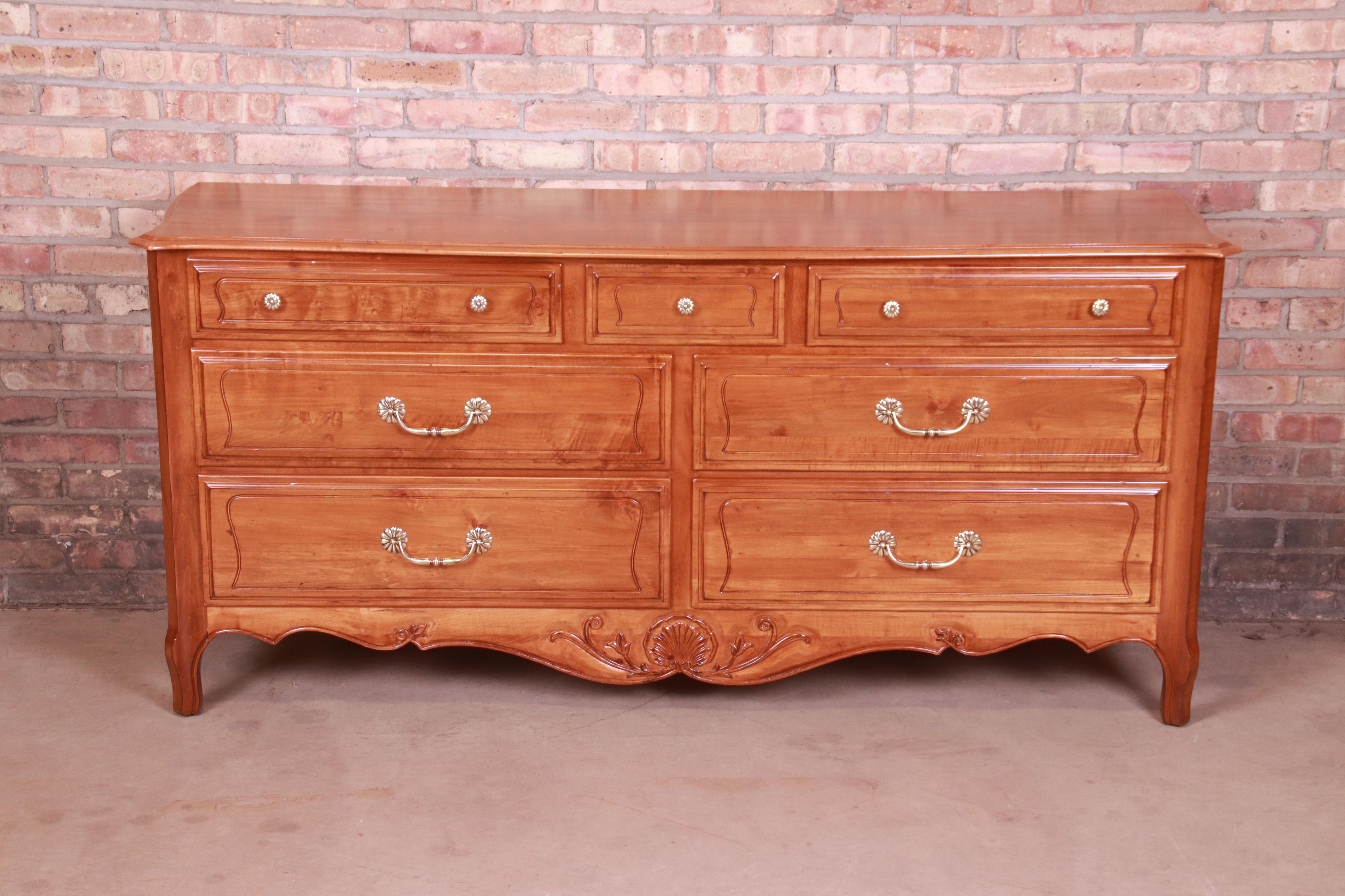 An exceptional French Provincial style seven-drawer dresser or credenza

USA, Circa 1990s

Carved solid cherry wood, with original brass hardware.

Measures: 68.5