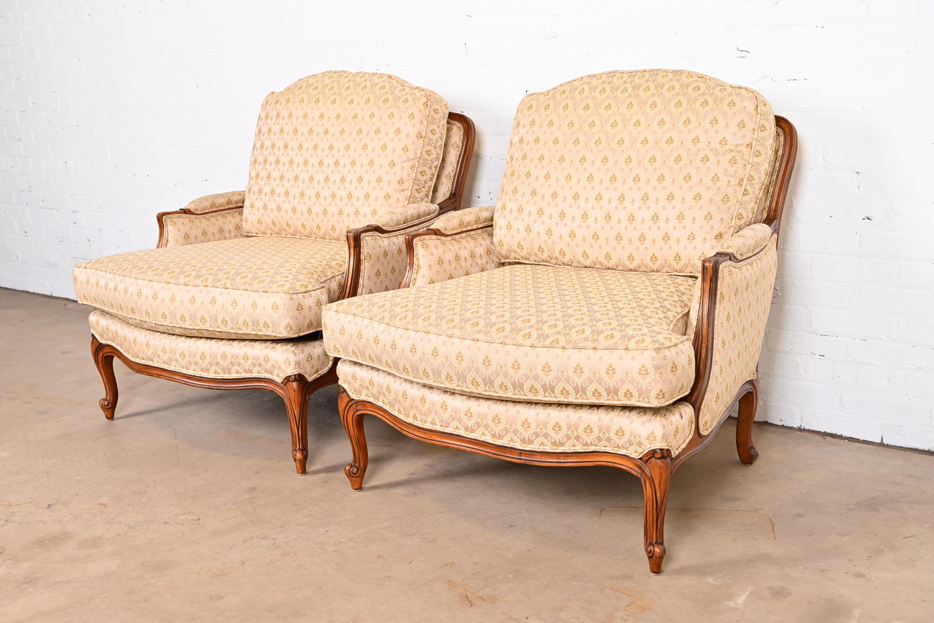 A gorgeous pair of French Provincial Louis XV style bergère lounge chairs

By Ethan Allen

USA, Circa 1980s

Carved walnut frames, with a traditional gold and pink foliate patterned upholstery.

Measures: 33