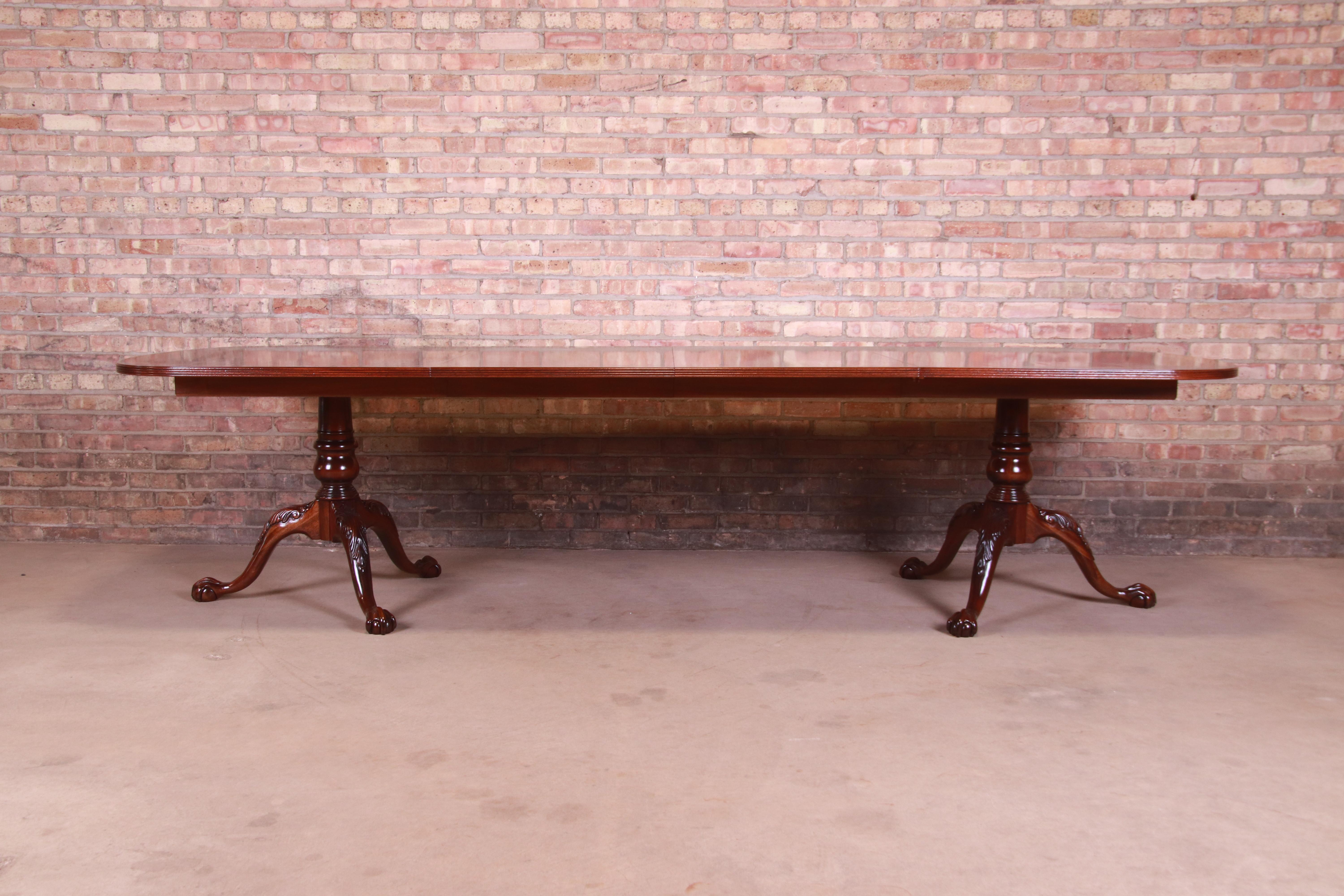 An exceptional Georgian style double pedestal extension dining table

By Ethan Allen

USA, late 20th century

Book-matched mahogany, with inlaid mahogany banding and carved solid mahogany pedestals with ball and claw feet.

Measures: 72
