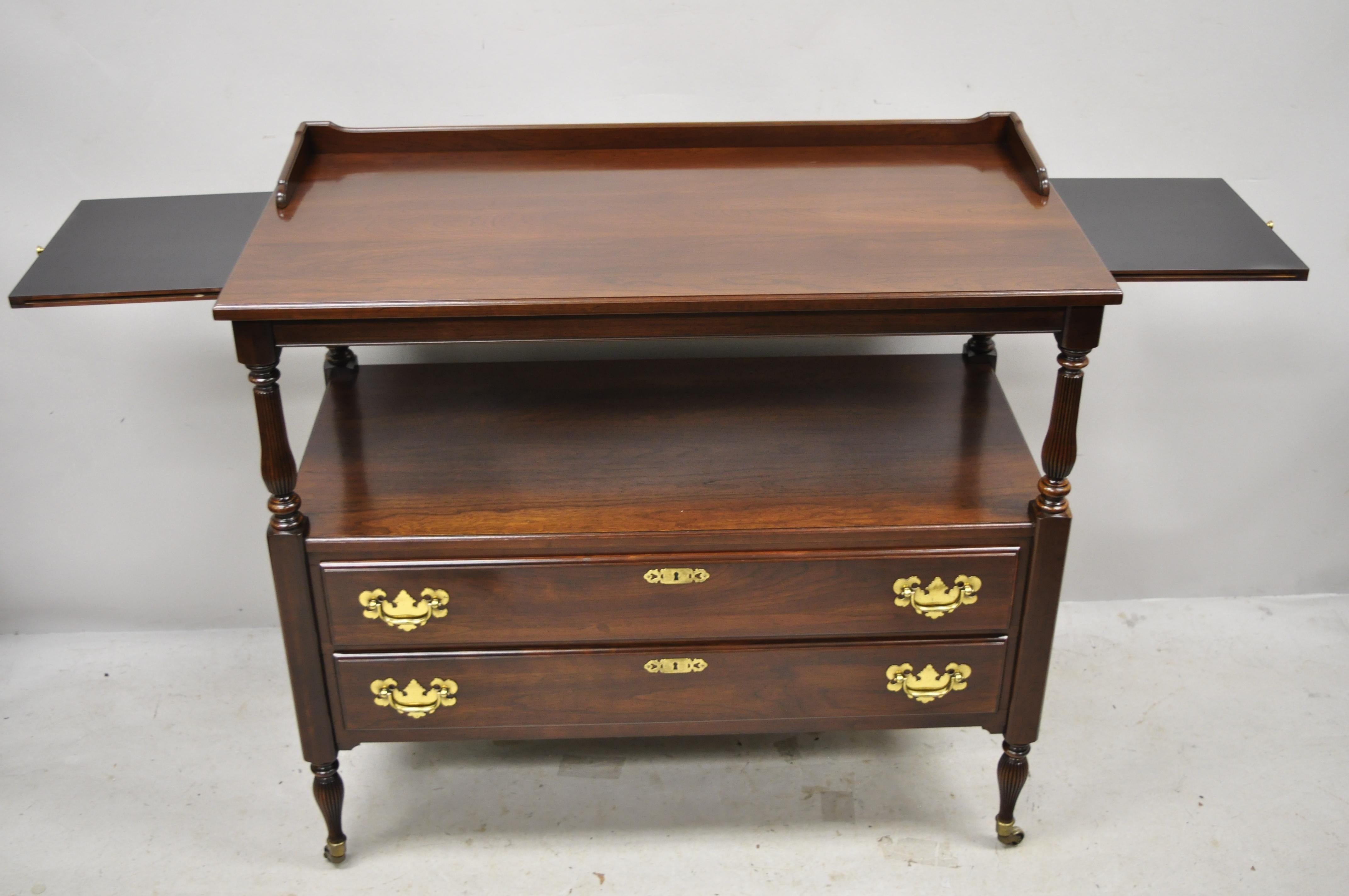 Ethan Allen Georgian court cherrywood server sideboard buffet Sheraton style. Item features 2 pullout / pull-out surfaces to sides, brass rolling casters, solid wood construction, beautiful wood grain, finished back, original stamp, 2 dovetailed