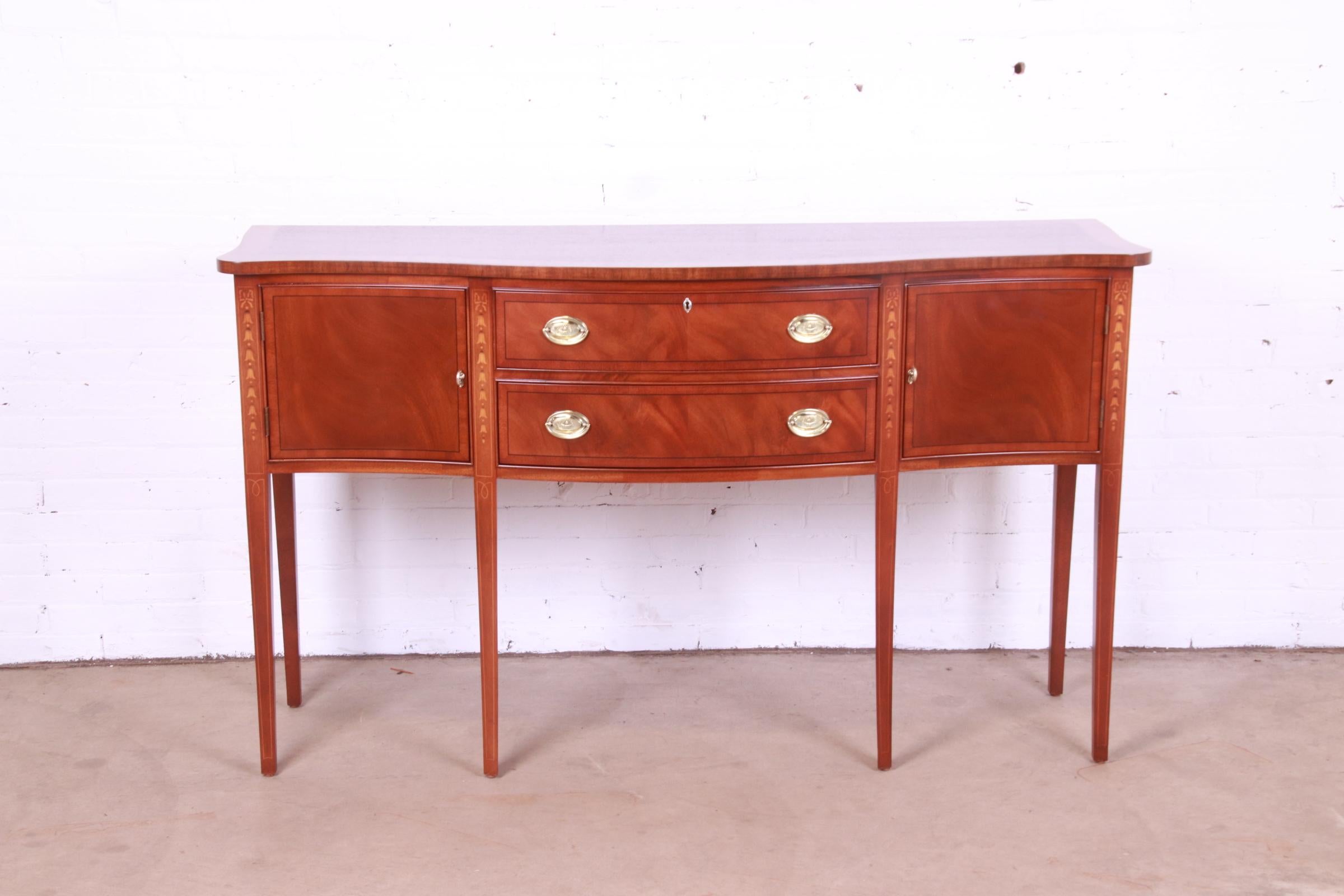 A gorgeous Hepplewhite or Federal style serpentine front sideboard, buffet, or credenza

By Ethan Allen

USA, late 20th century.

Flame mahogany, with inlaid satinwood marquetry, and original brass hardware.

Measures: 65.5