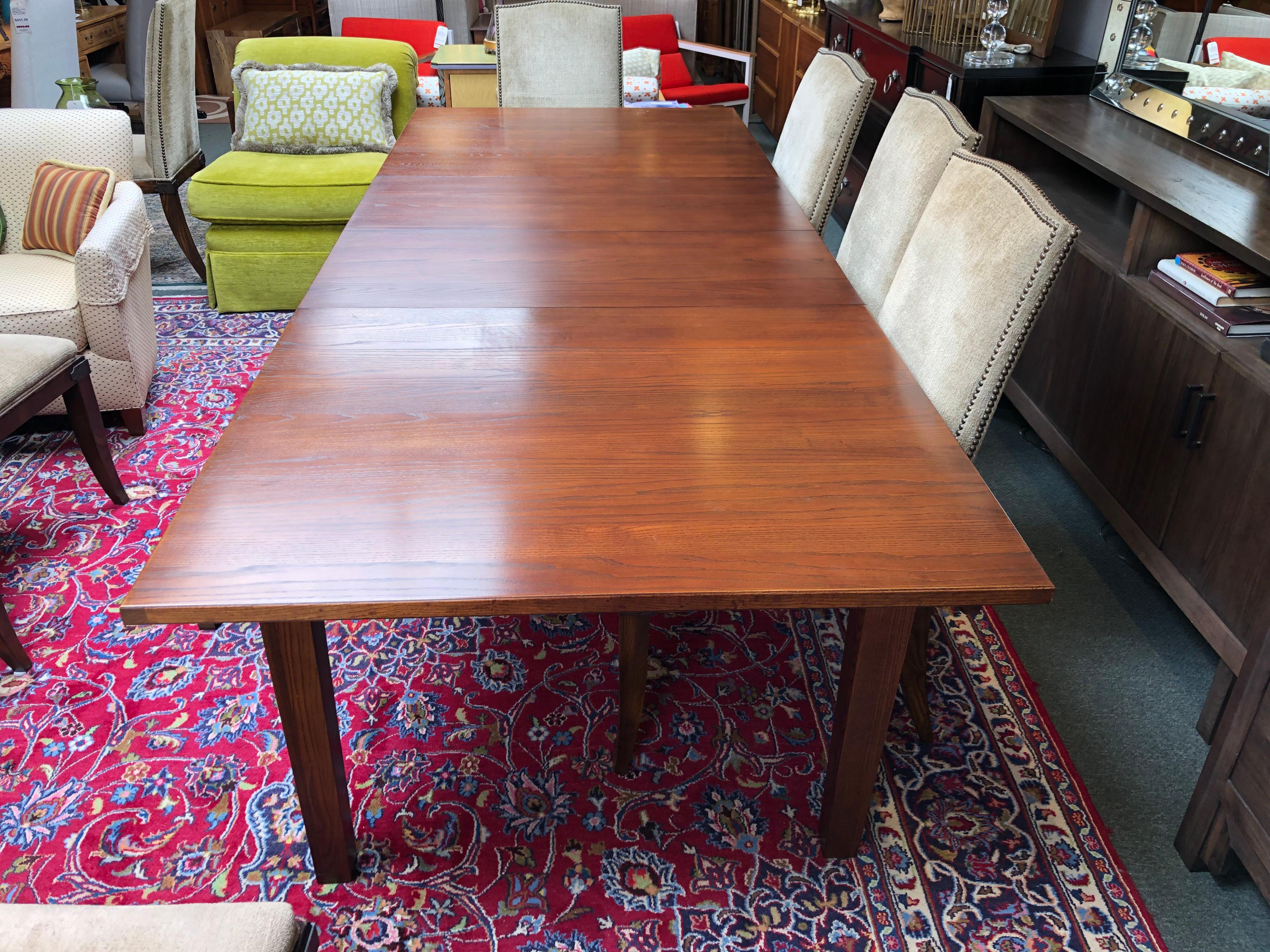 We presents a Horizon collection table by Ethan Allen. Modern lines within a nicely textured wood grain tabletop giving the table just enough of a Classic feel. Accompanied with two 18 inches extensions. The legs are slightly tapered and the piece
