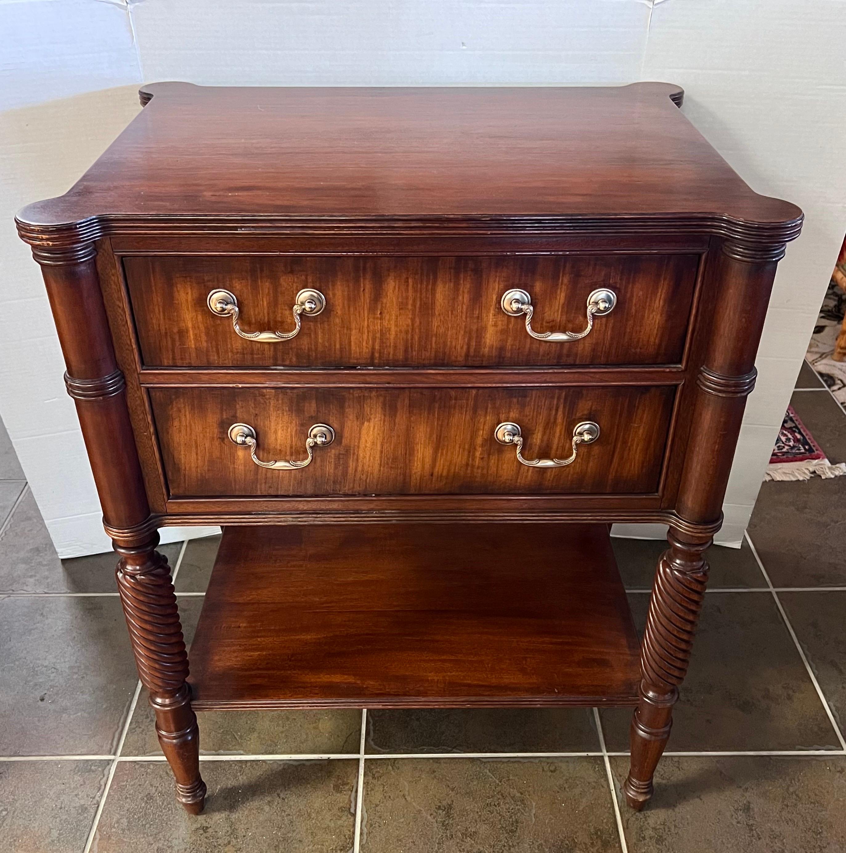 Elegant mahogany two drawer nightstand of side/end table.  Note shelf on bottom for extra storage.  Top is rectangular with rounded corners that cap the intricately turned fluted legs.