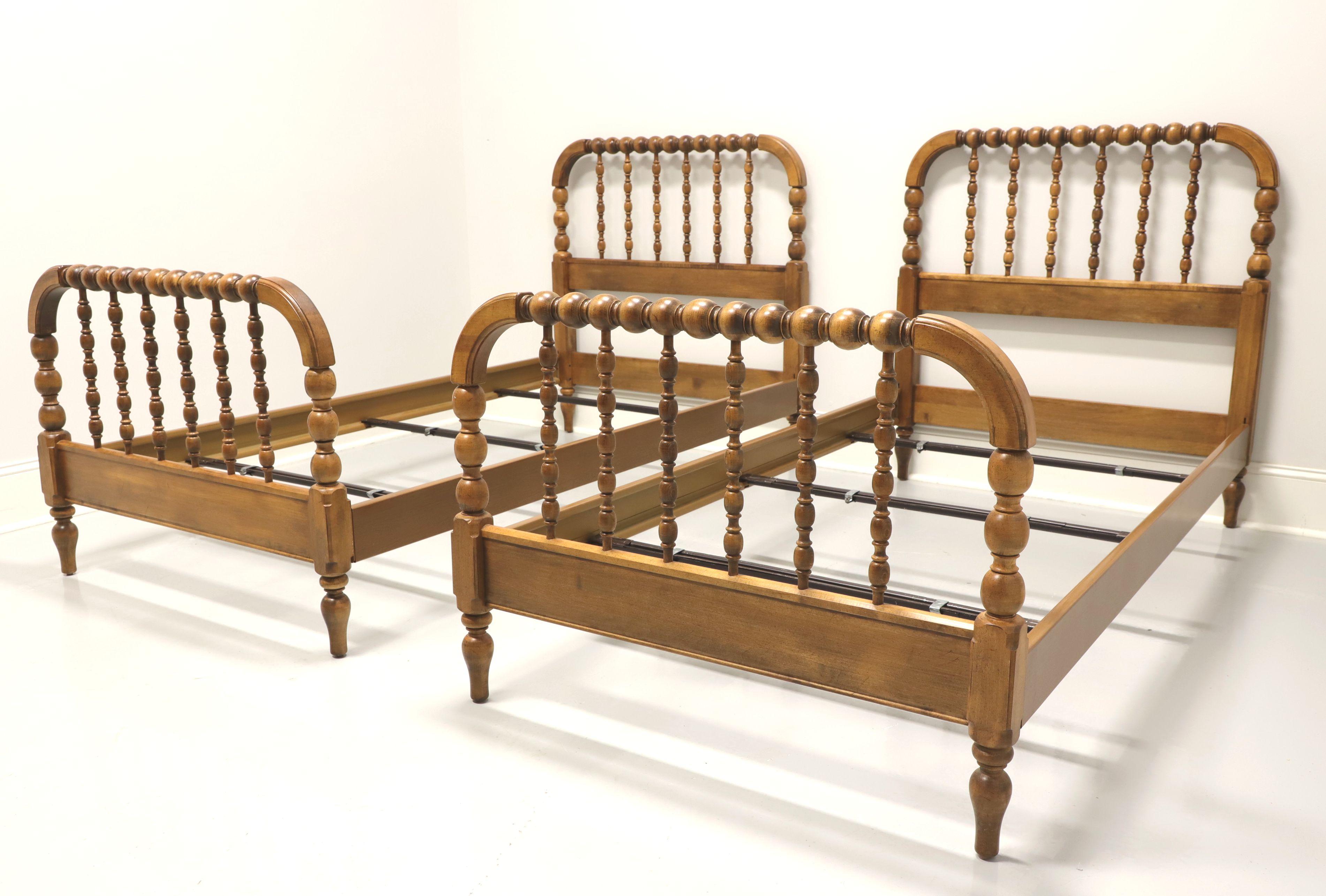 A pair of Jenny Lind style twin beds by Ethan Allen. Solid maple headboard and footboard with clip held wood grain metal side rails. Features headboard and matching footboard with classic arched open spool turned design and three metal slats that