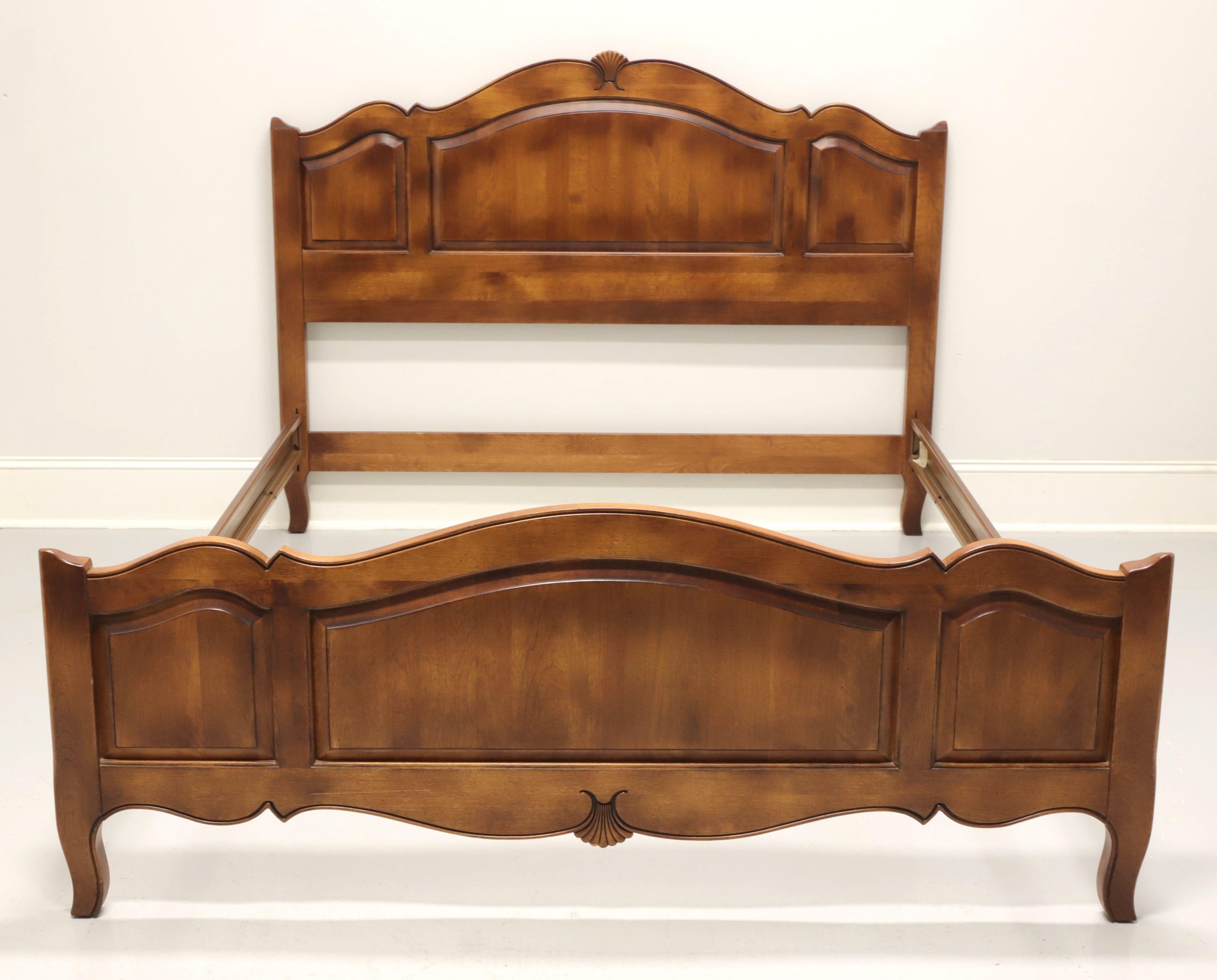 A French Country style queen size bed by Ethan Allen. Solid maple headboard and footboard with clip held wood grain metal side rails. Features a headboard with a curved top, decorative carved fan to top center and three panels. Footboard also has a