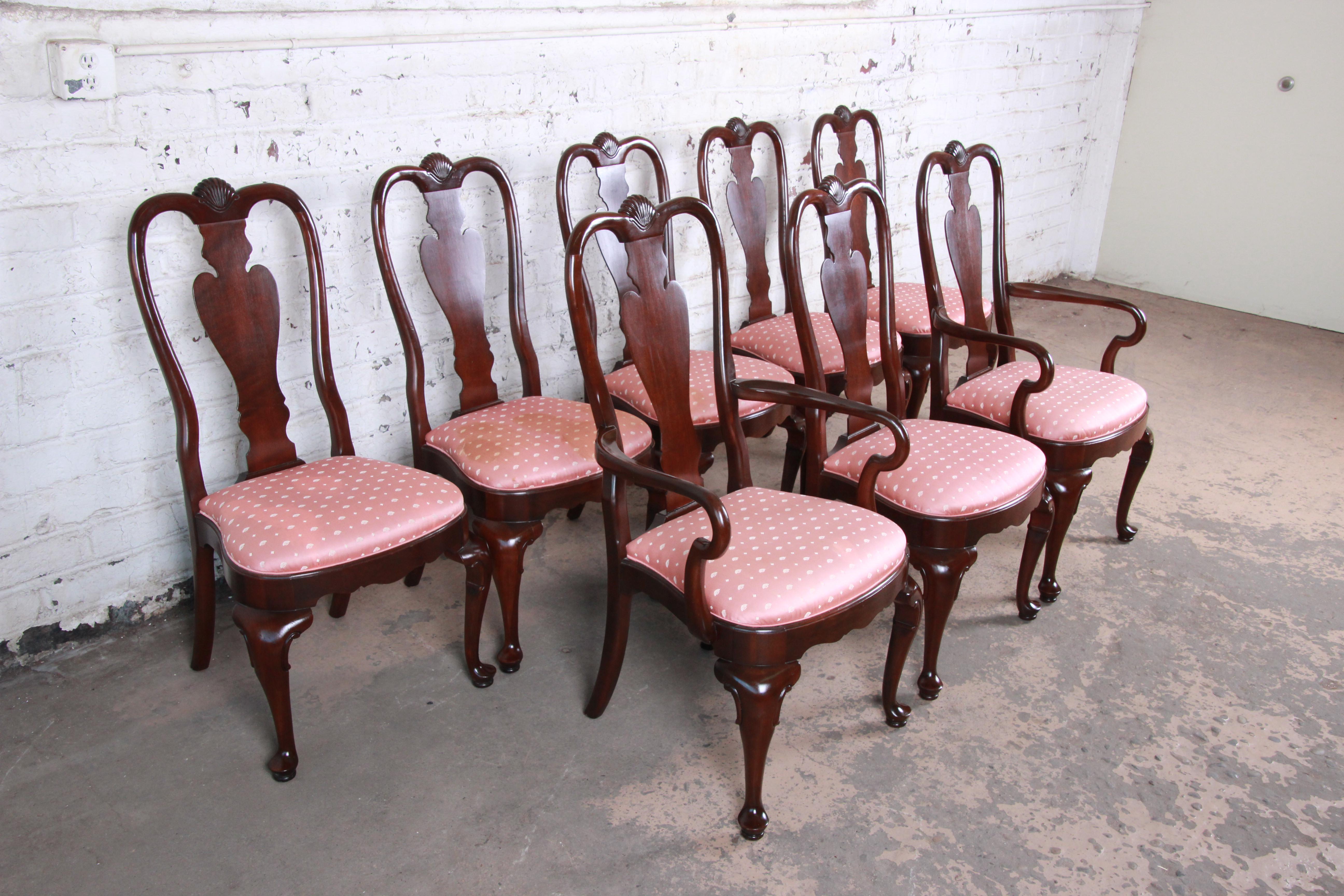 A gorgeous set of eight Queen Anne style dining chairs by Ethan Allen. The set includes two captain armchairs and six side chairs. The chairs feature solid cherrywood construction and nice carved wood details with a shell motif. The original pink