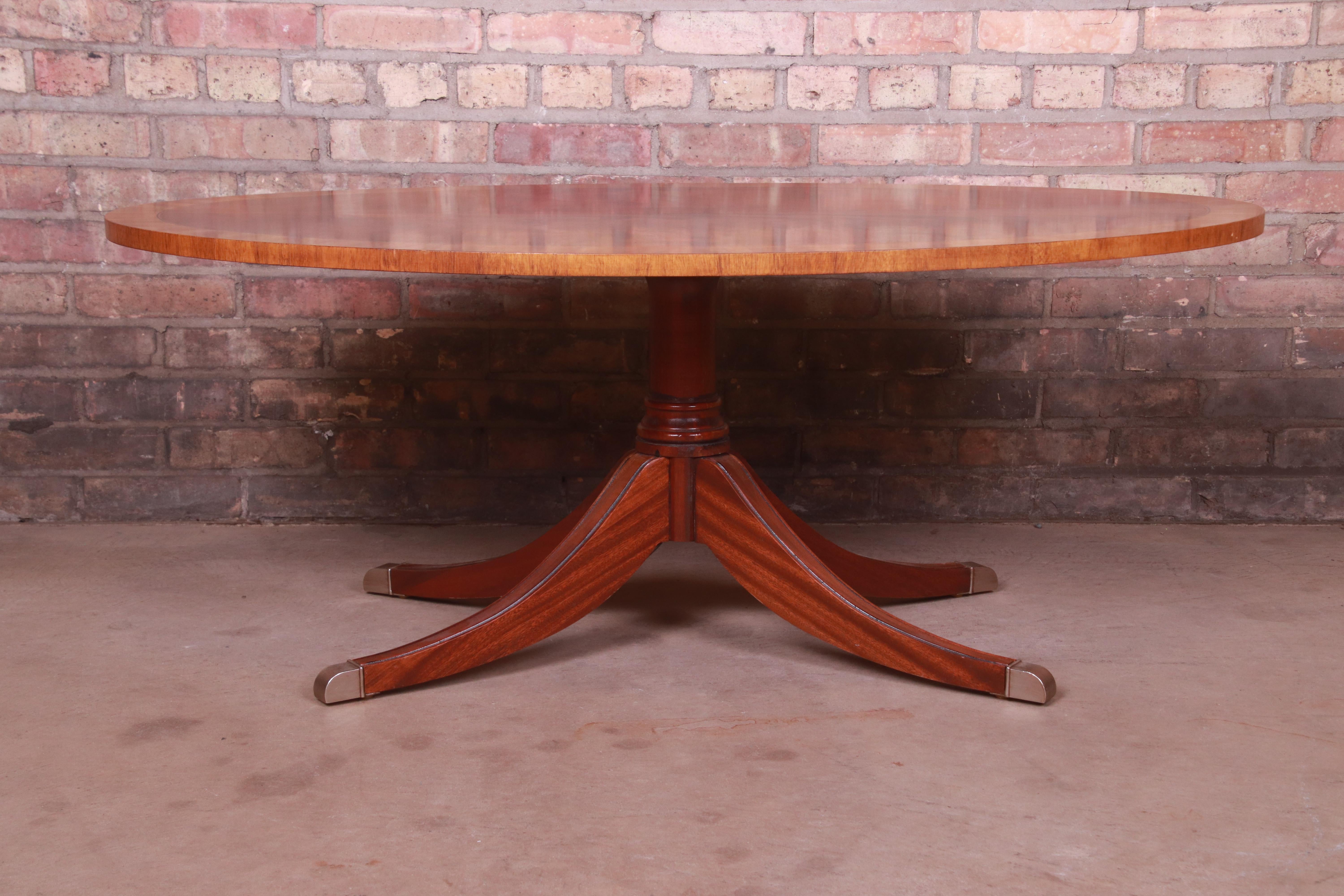 A gorgeous Regency style pedestal coffee table

By Ethan Allen

USA, Circa 1990s

Flame mahogany top with satinwood banding, carved solid mahogany pedestal, and brass-capped feet.

Measures: 48