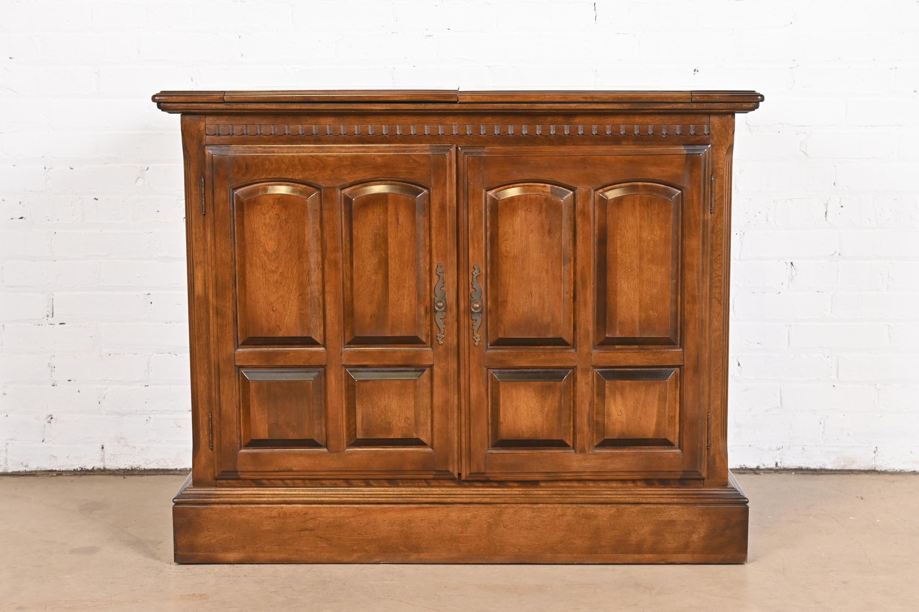 A beautiful Regency or Georgian style flip top rolling buffet server or bar cabinet

USA, Circa 1970s

Carved maple, with original brass hardware.

Measures: 41.5