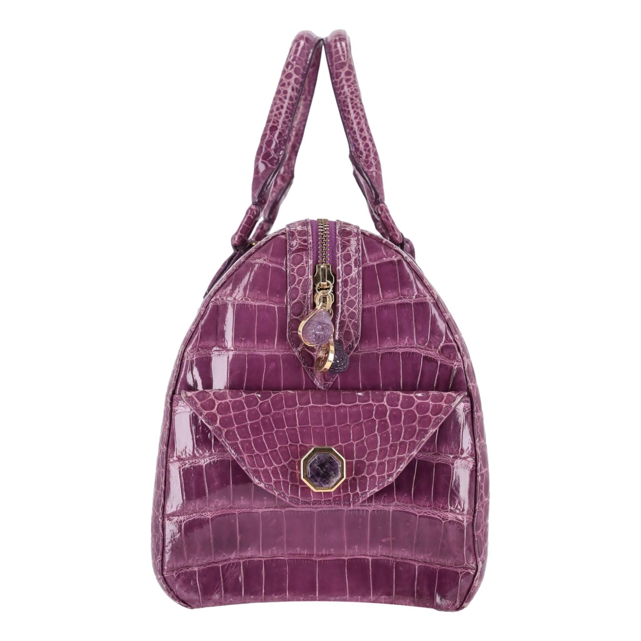 Ethan K Crocodile Skin Bowler Bag

Lustrous shiny purple Crocodile skin with gold hardware and oversize rhinestone embellished zippers and side pockets.

Removable shoulder strap, rolled carry handles and zipped top leading to bright yellow