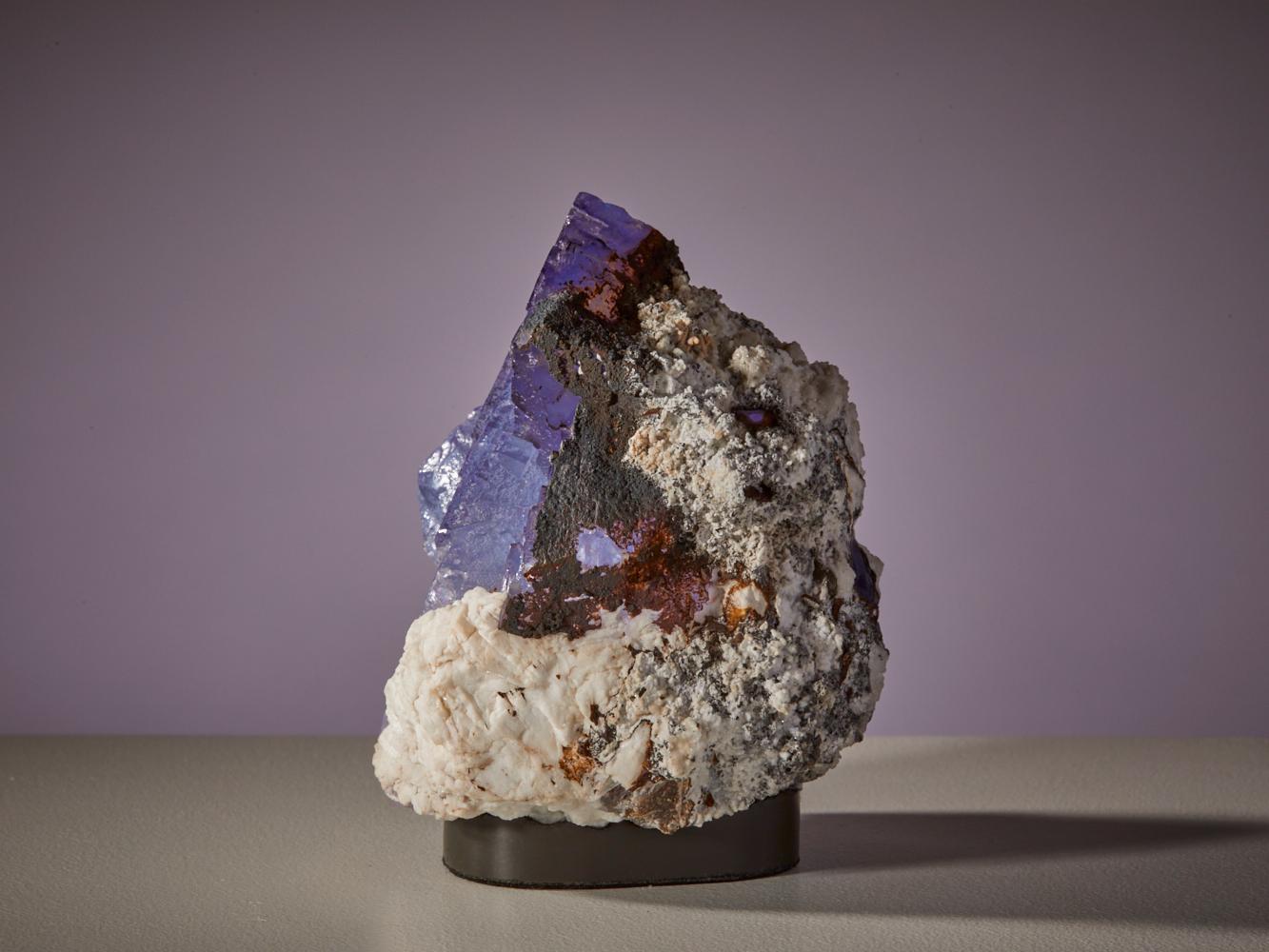 Immerse yourself in the captivating allure of this exquisite fluorite specimen from Taourirt, Debdou, Morocco. This stunning piece features translucent blue fluorite crystals elegantly set in a matrix of barite, with delicate red accents adorning