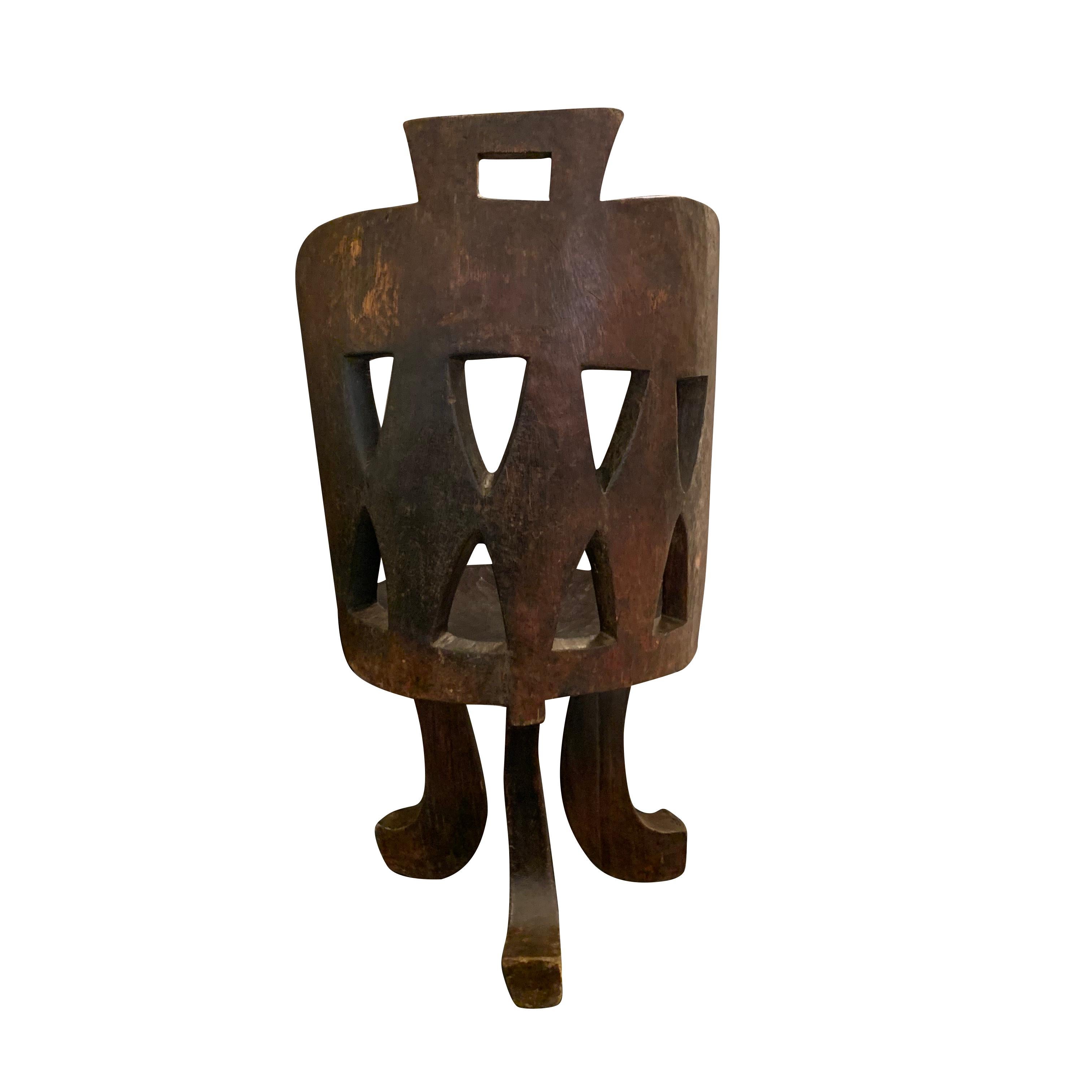 Ethiopian dark brown hand carved wood side chair.
This chair is carved in the traditional Ethiopian style. 
Diamond shapes are carved out of the back of the barrel back shape which sits on three curved legs.
This is a very attractive and unique