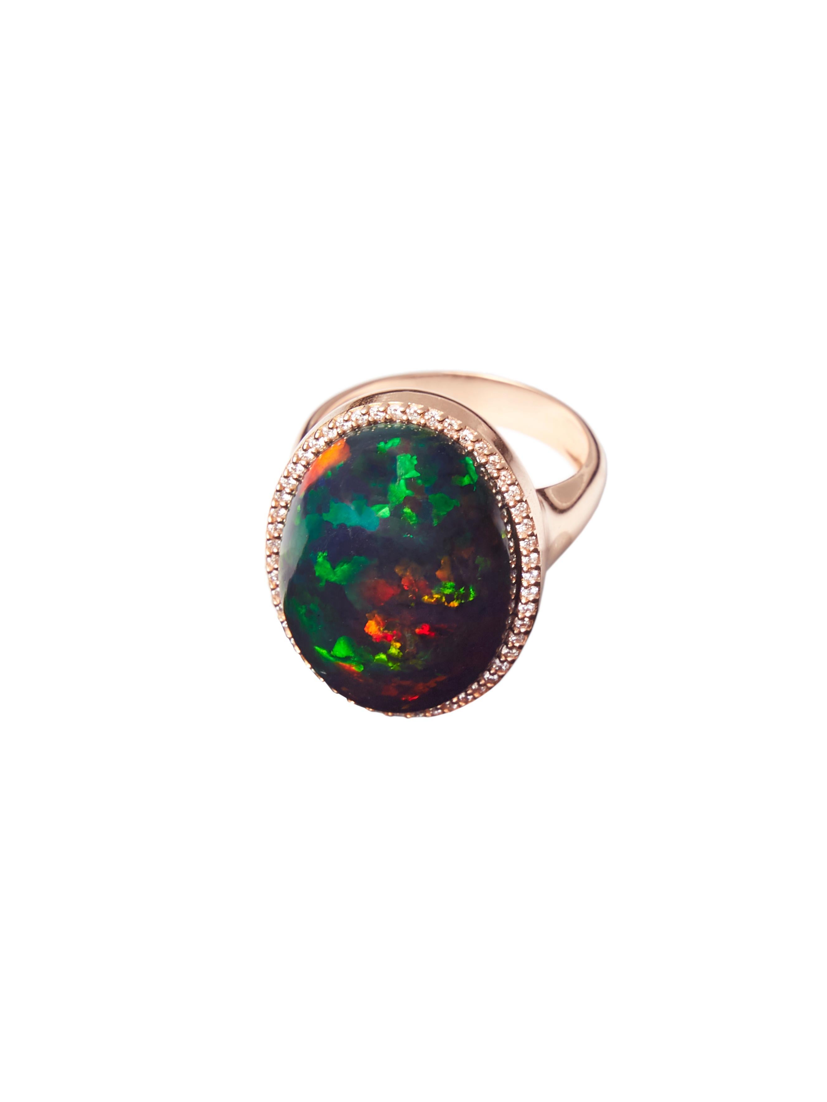 This custom made ring in 18 karat rose gold features an oval cabochon Ethiopian black opal measuring 20 mm x 15 mm which is set in a halo of in total 0.21 ct diamonds to bring out the mesmerizing play of colour of this 12 ct top quality gem even