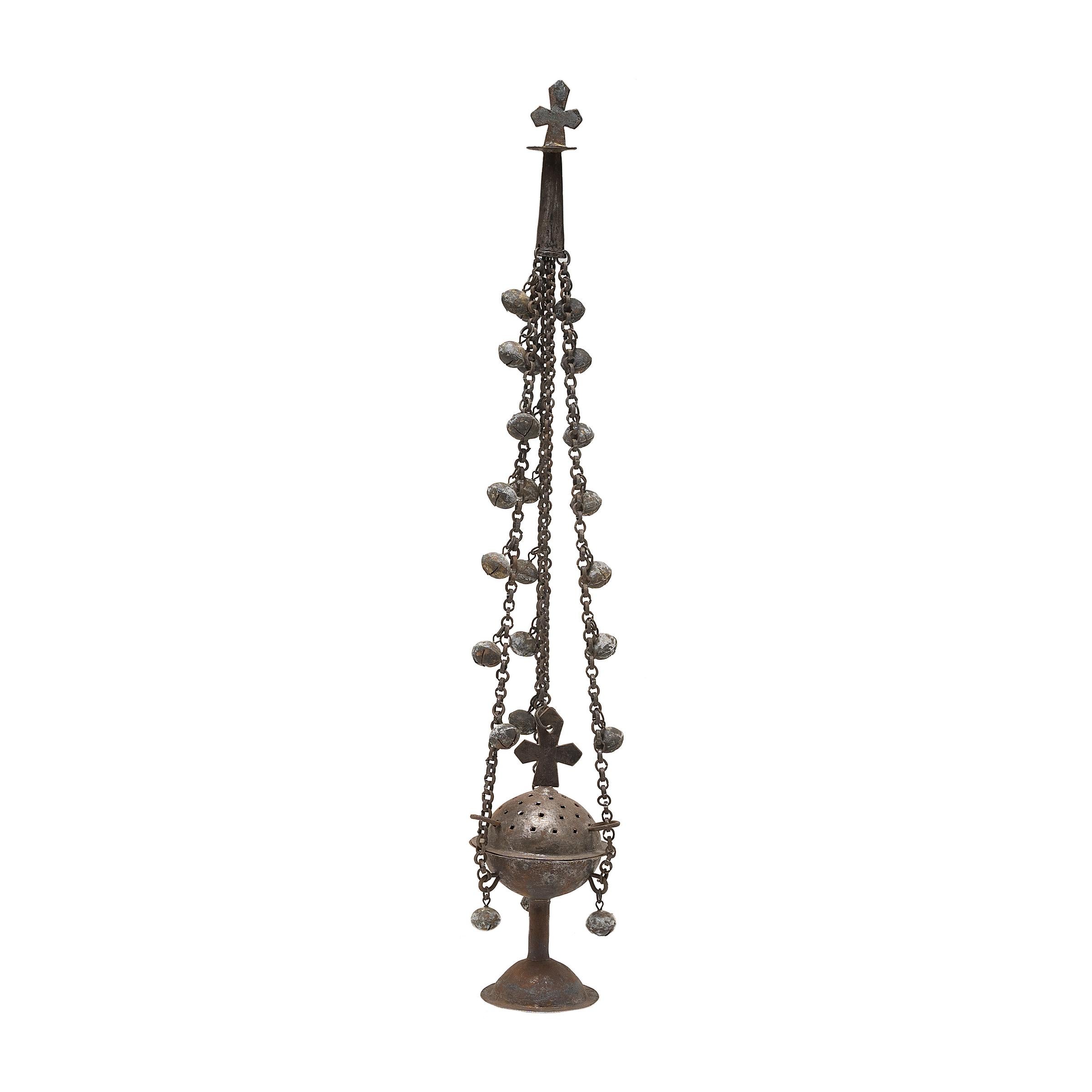 This sculptural bronze object is a 19th-century liturgical censer, or thurible, used for guided prayer and ritual ceremony within the Coptic Orthodox Church. Blessed by the Priest prior to use, the censer was lit with incense such as frankincense,
