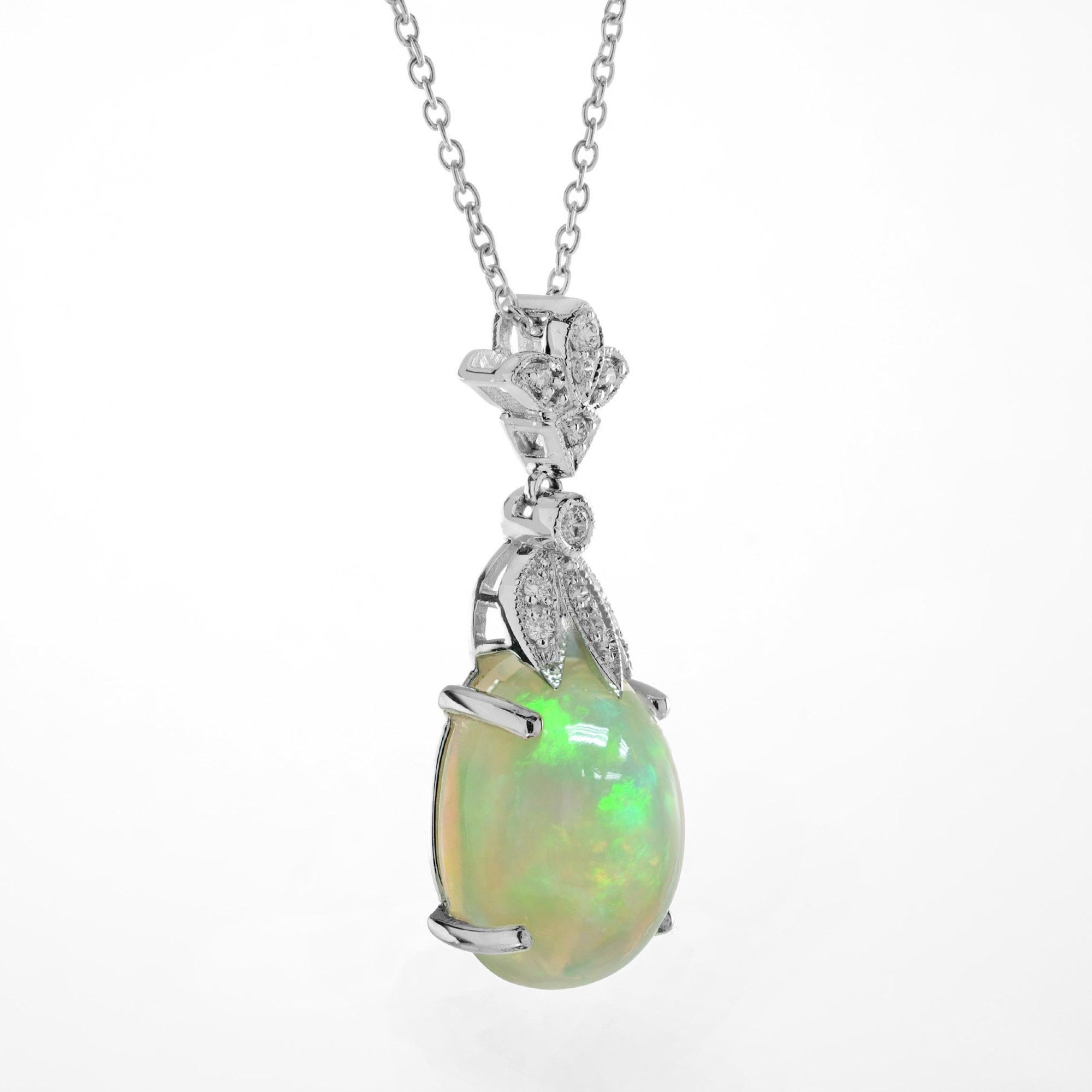 Features a luminous Ethiopian opal—renowned for its vibrant play of color and natural fire. The opal shifts beautifully with every movement, revealing flashes of green, gold, pink, and blue. Hanging the opal, brilliant white diamonds are