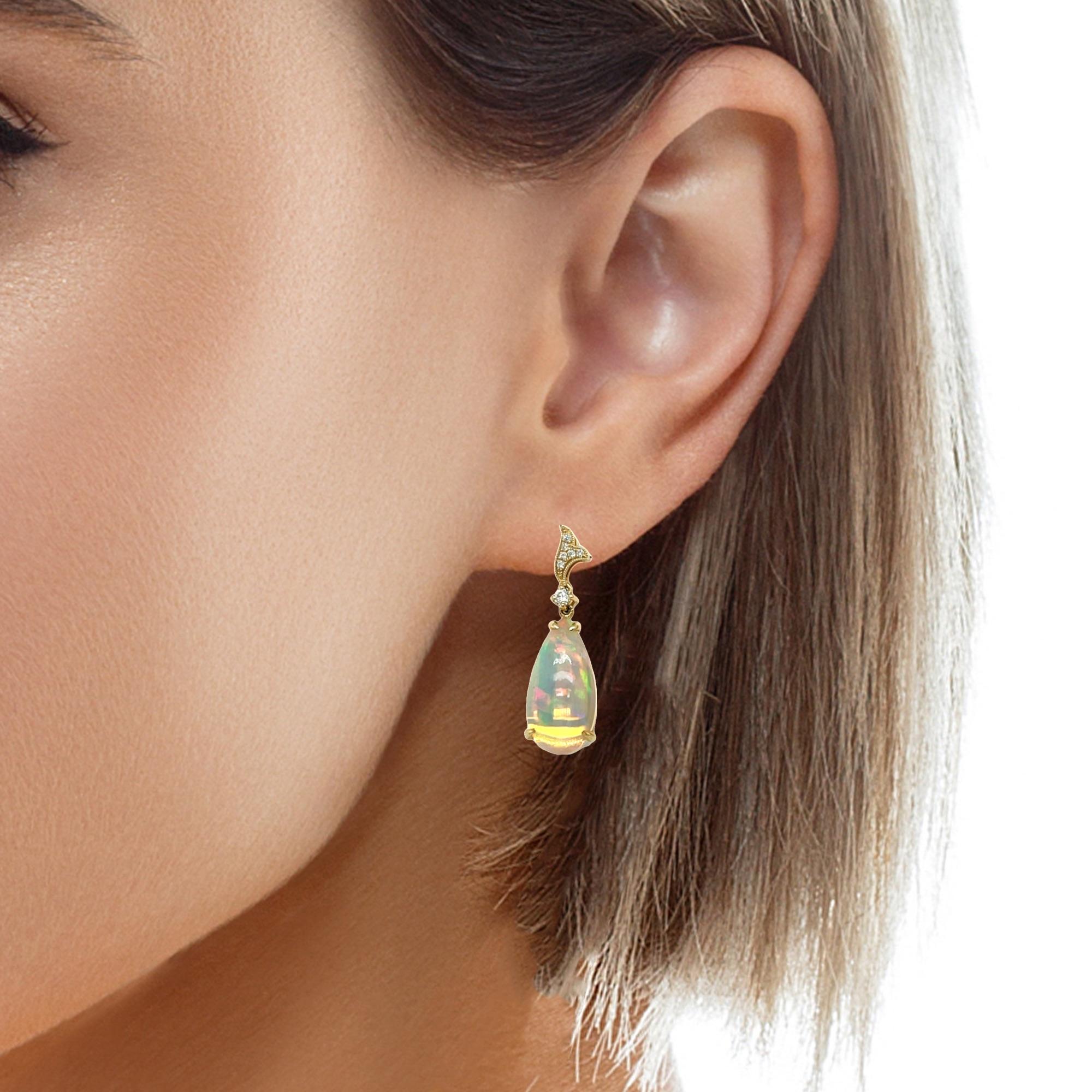 These stunning genuine Teardrop Ethiopian Opal and diamond dangling earrings are a beautiful accessory for your special event. These earrings have a 18x9 pear shaped opal which has a 4 prong setting in 14 karat yellow gold. There are sparkling