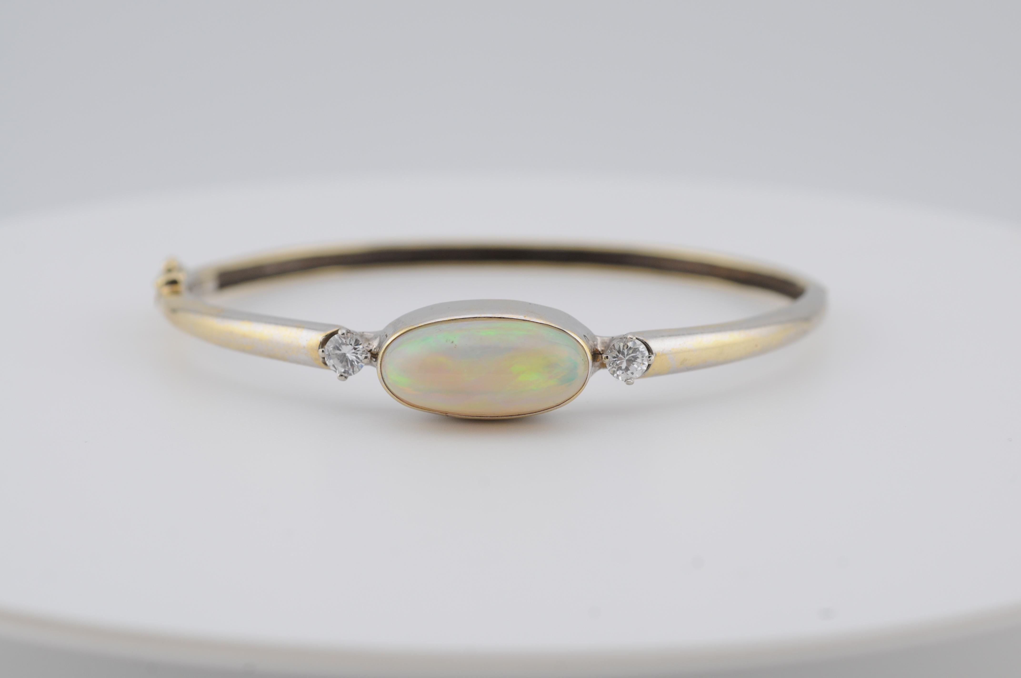 Un anello affascinante con un opale etiope naturale di circa 4 carati, che mostra un gioco di colori vivido e vivace senza crepe visibili. L'opale mostra un bellissimo mix di lampi spettrali sotto la luce, tipico di un materiale di alta qualità