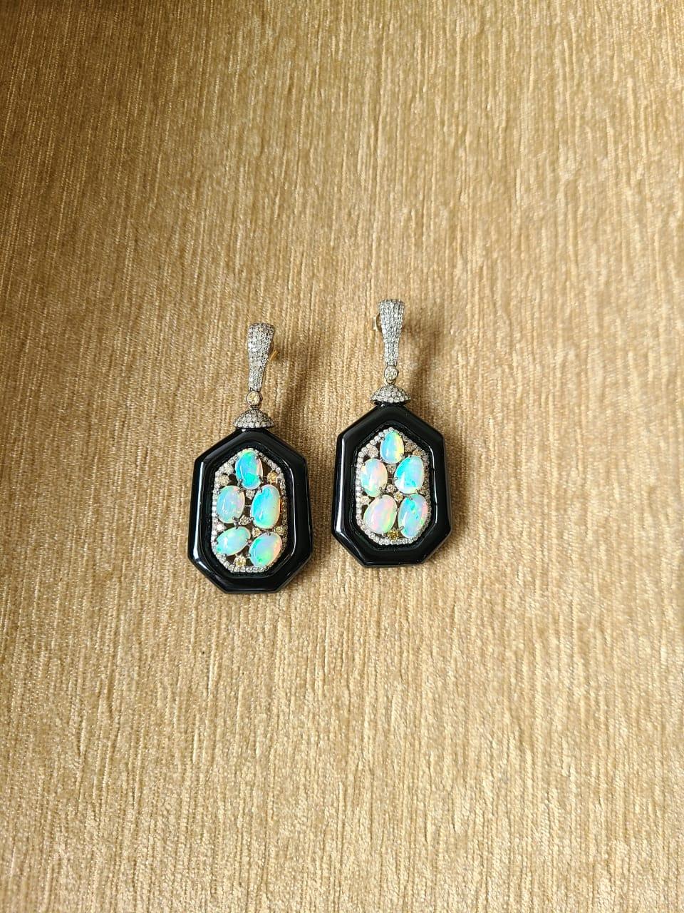 A very gorgeous Opal and Black Onyx Dangle Earrings set in 14K Gold & Diamonds. The Opals are of Ethiopian origin and weigh 8.10 carats. The weight of the Black Onyx is 43.18 carats. The weight of the Diamonds is 2.12 carats. The dimensions of the