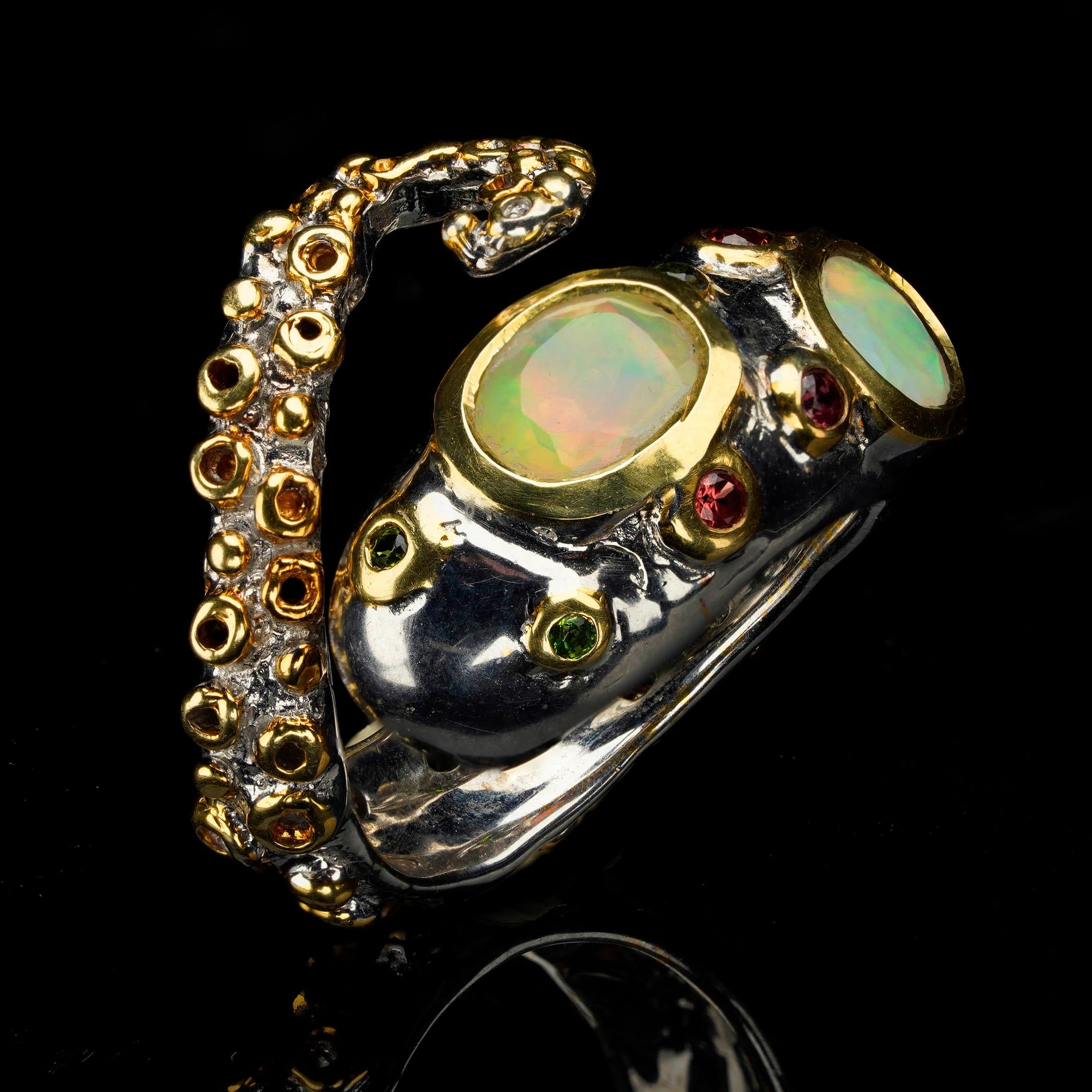 This truly unique sterling silver octopus tentacle ring fuses marine animalia with the fire and sparkle of Ethiopian Opals, faceted Chrome Diopsides, and faceted rare orange Sapphires. The tentacle design of this vividly colorful multi-gemstone