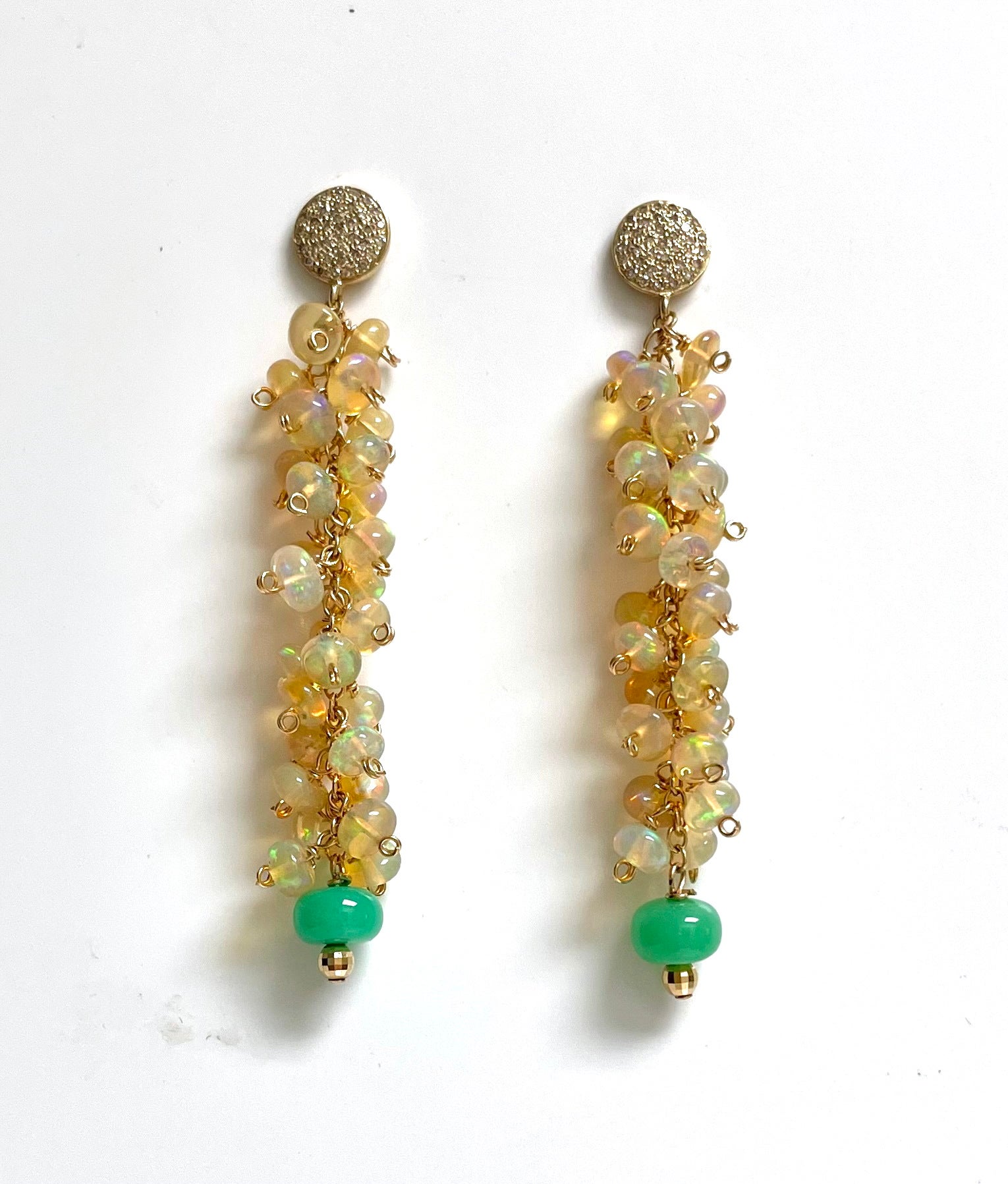 Description
Light up a room as you walk in style glowing in opal iridescence. These exquisite Ethiopian Opal hand crafted clusters are of superior quality and harmoniously interact with the vibrant green Chrysoprase drops creating a luscious and