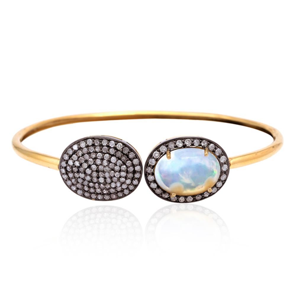 A beautiful bangle bracelet handmade in 18K yellow gold and sterling silver. It is set in 3.2 carats Ethiopian opal and 1.2 carats of sparkling diamonds. 

FOLLOW  MEGHNA JEWELS storefront to view the latest collection & exclusive pieces.  Meghna
