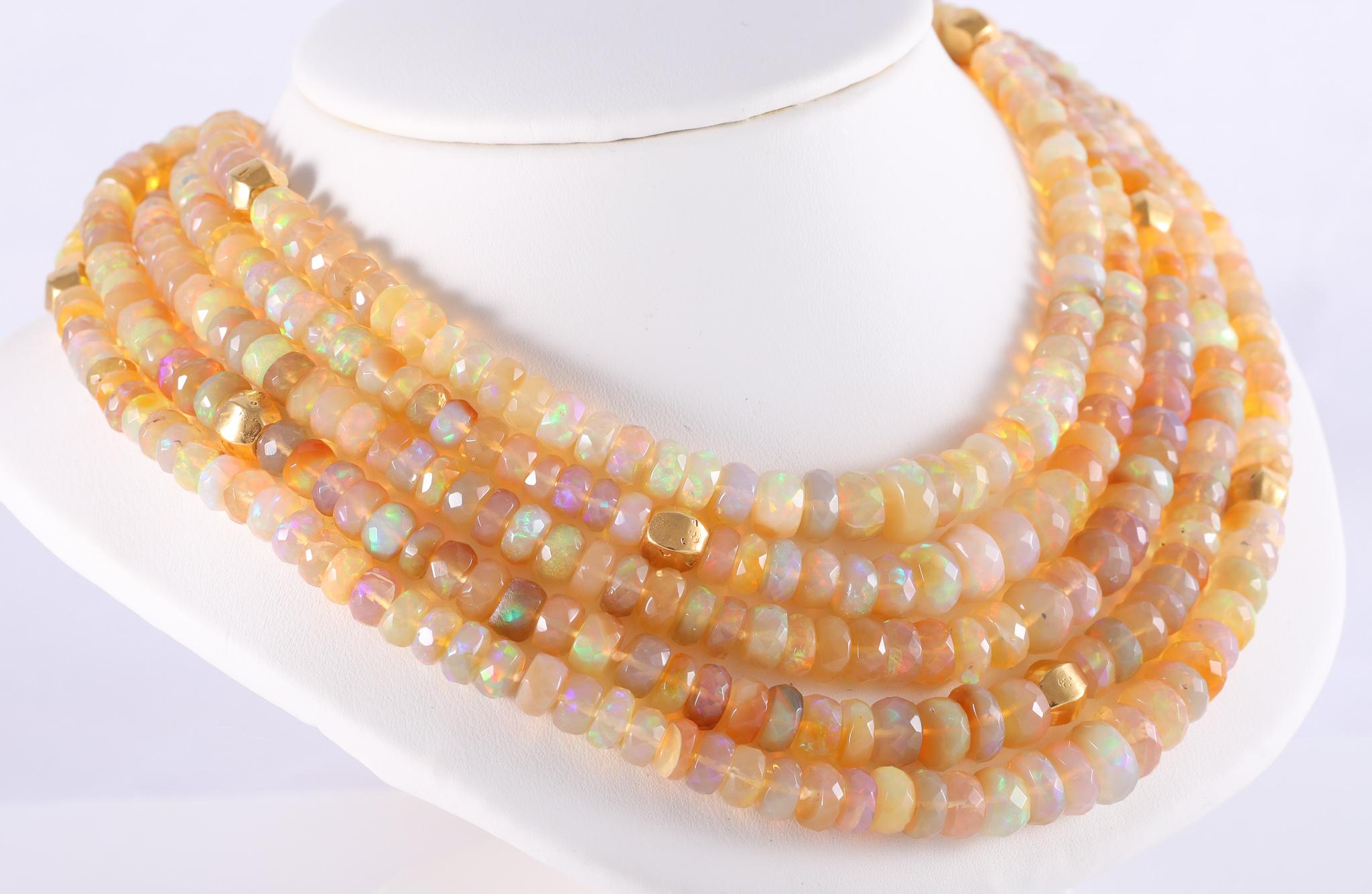 Five strands of fully saturated opal beads are accented with 18k yellow gold smooth beads. This is a sunshine necklace full of lively iridescent colors. These Ethiopian opal beads are rough cut faceted rondelles and have a more natural look, while