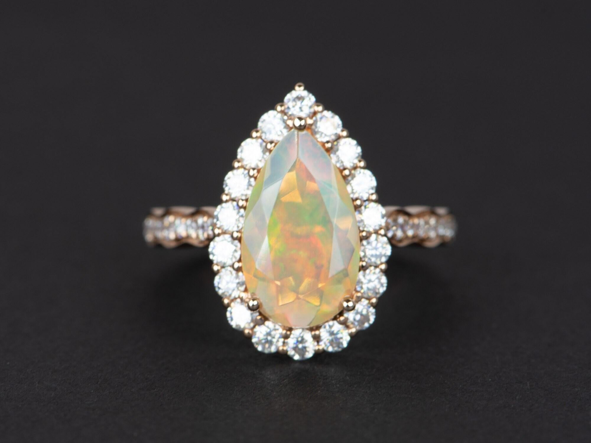 ♥ Solid 14K gold ring set with a beautiful pear-shaped Ethiopian opal in the center, flanked by a halo of bright white moissanites. The shank is also decorated with gradual-sized moissanites for maximum sparkle!
♥ The opal is incredibly fiery with a