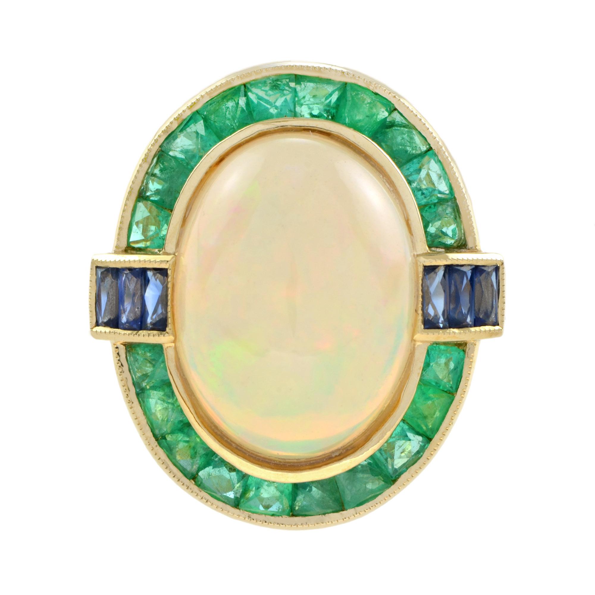 This gorgeous Opal cocktail ring crafted of 18k yellow gold and features a 6.49 carat center stone. The ring is and accented with French cut emerald and punctuated east and west with French cut sapphires . 

Ring Information
Style: Art Deco
Metal: