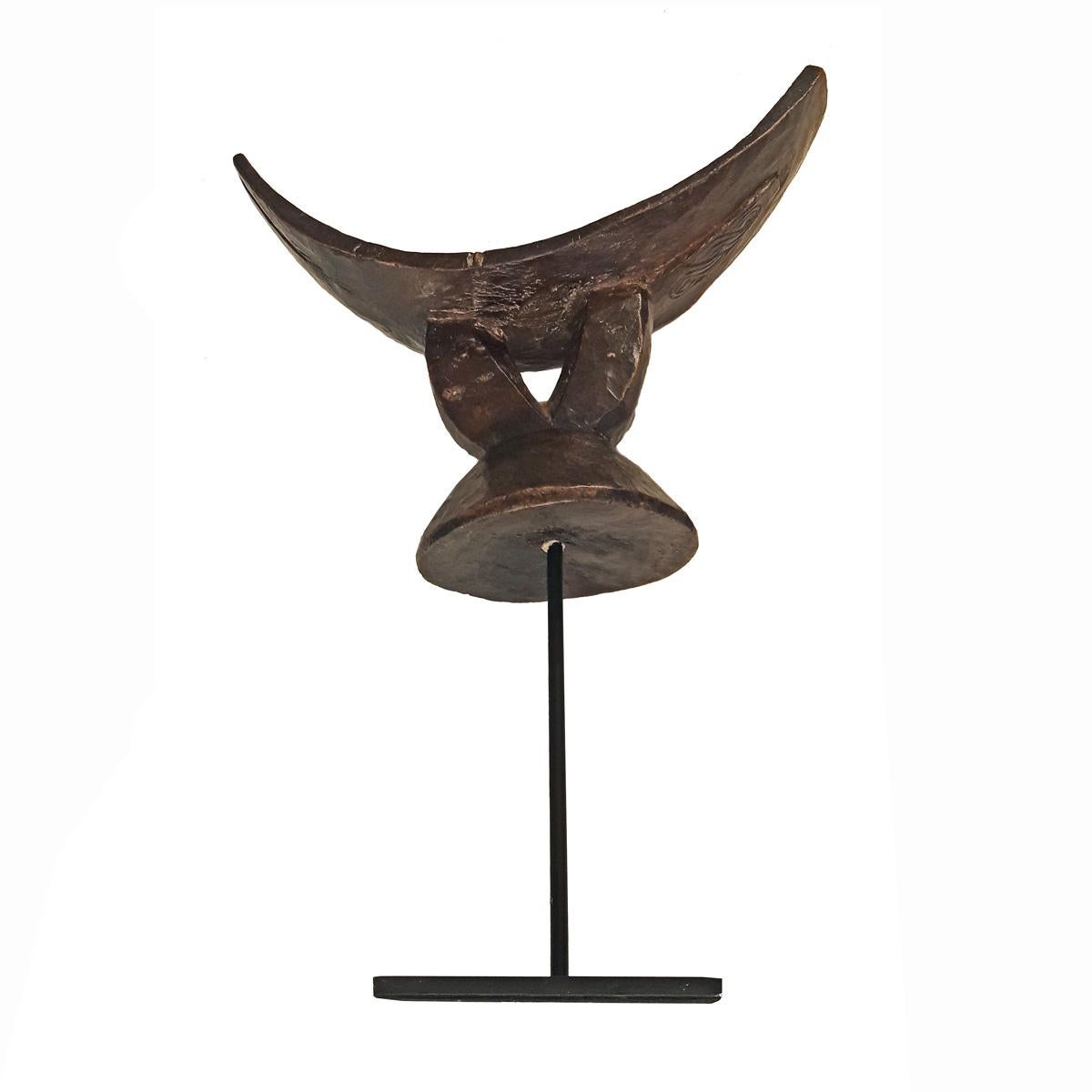 A headrest or stool, hand carved out of a single piece of teak wood. From Ethiopia, late 20th century. Mounted on a 4