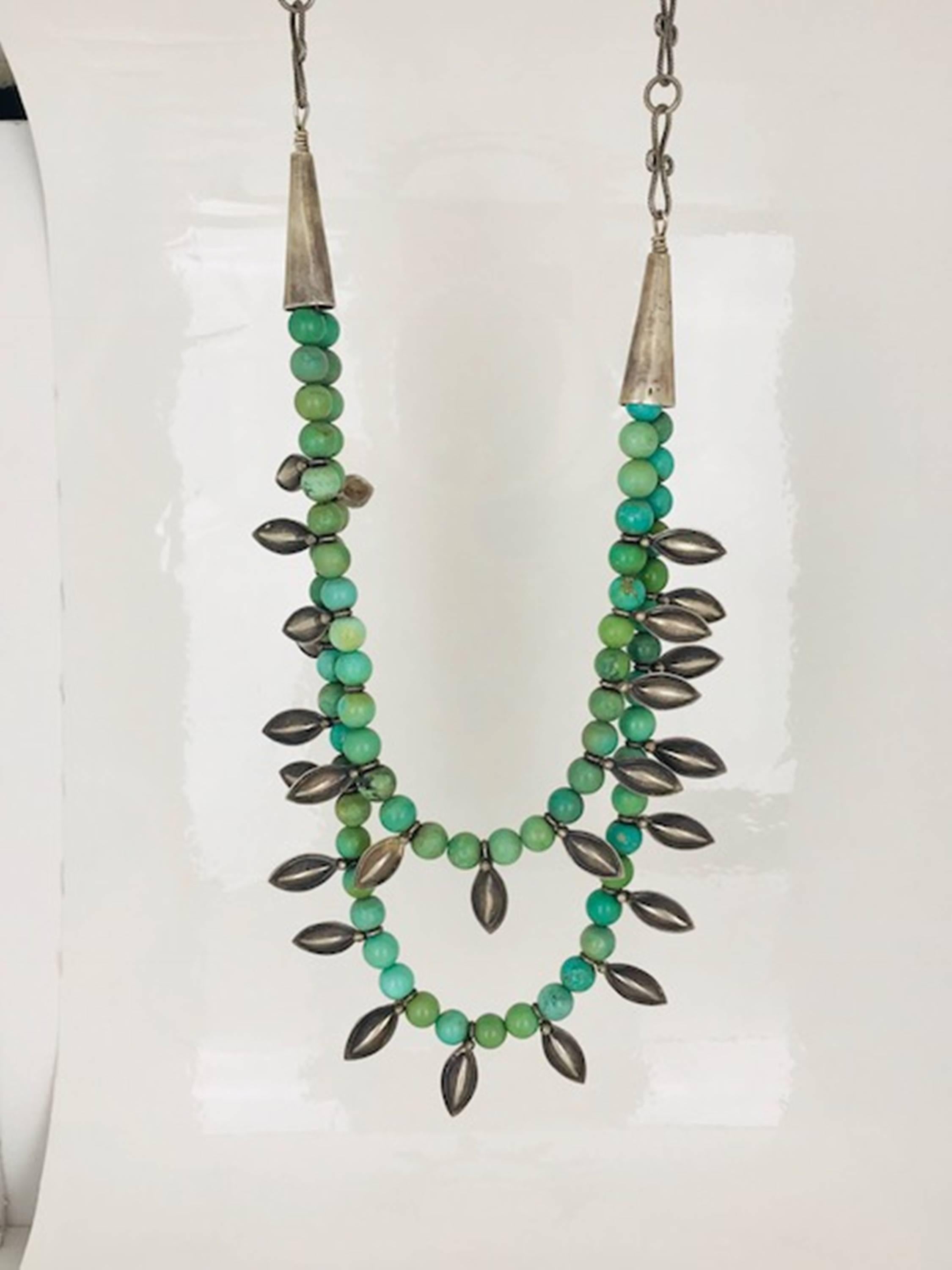 Handmade, Ethiopian tiered necklace with sterling silver leaf accents. The turquoise beads are 7-7.50 in diameter on this adjustable length necklace. 

The length of the tiered is 22 inch bottom necklace and 19 inch, top necklace. 
The necklace is