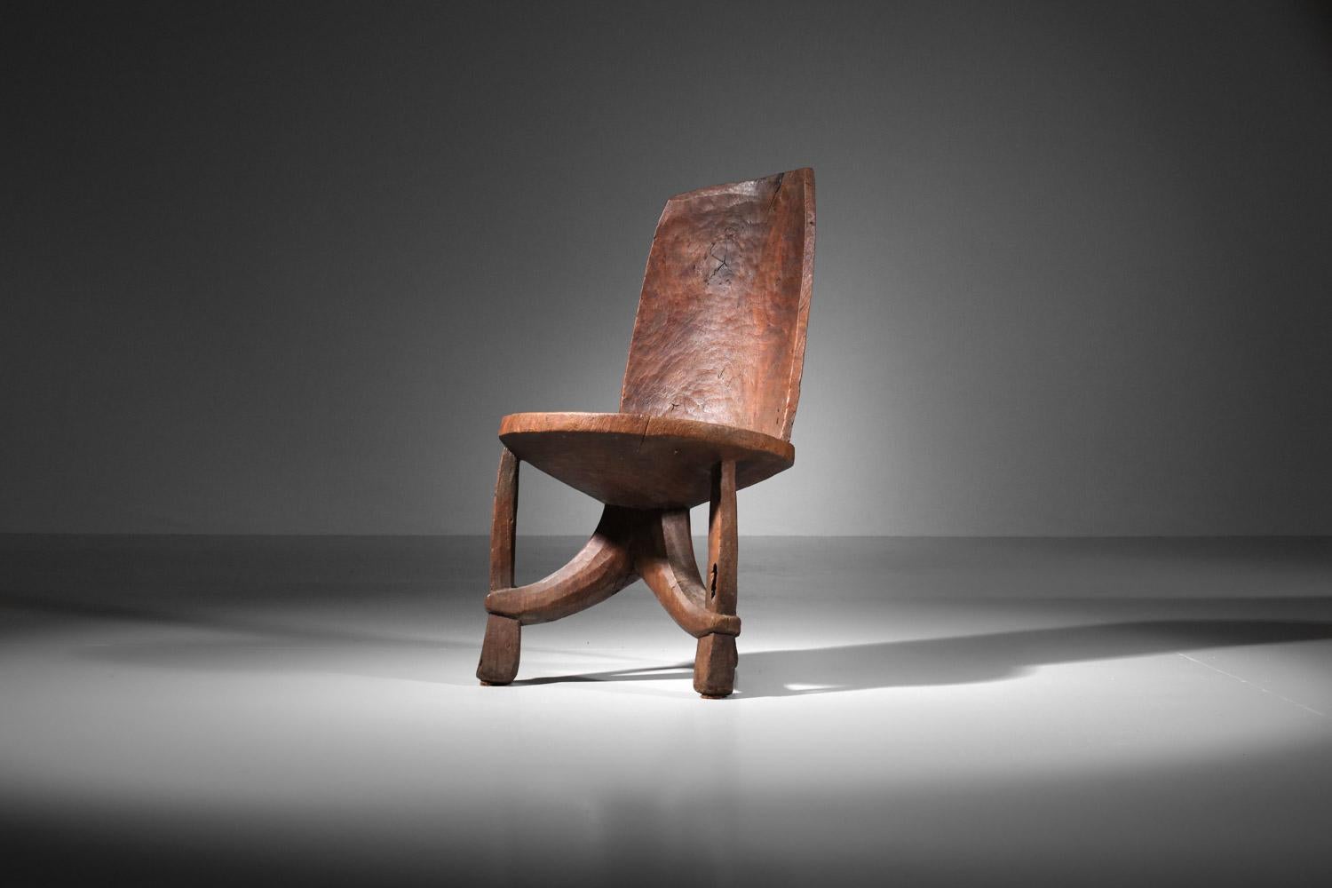 Chaise ethnique africaine en bois massif sculpté à la main, travail artisanal de qualité avec son piétement tripode en un seul morceau. Très bel état vintage avec une belle patine du temps (voir photos). Nous recommandons de l'utiliser en chaise de