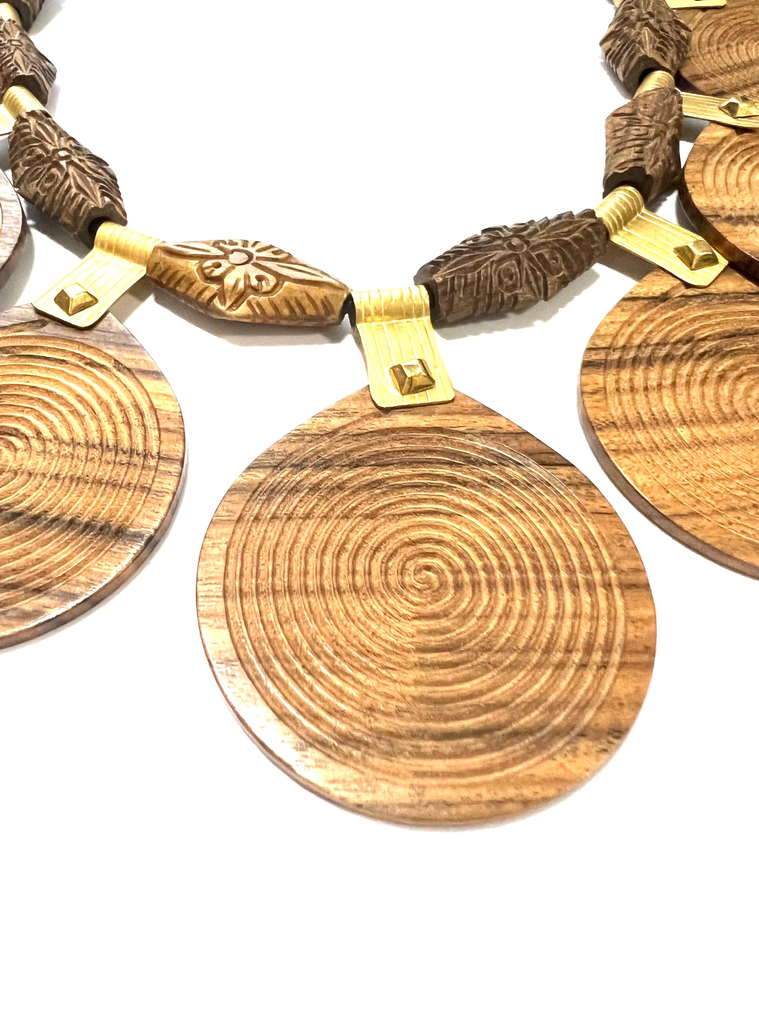 Diese ethnische Halskette aus Palissander und 18-karätigem Gelbgold ist ein einzigartiges Stück, das den Reichtum von Palisander mit der Eleganz von satiniertem Gelbgold verbindet. Auf schwarzem Leder aufgefädelt, bietet diese Kette abwechselnd 9
