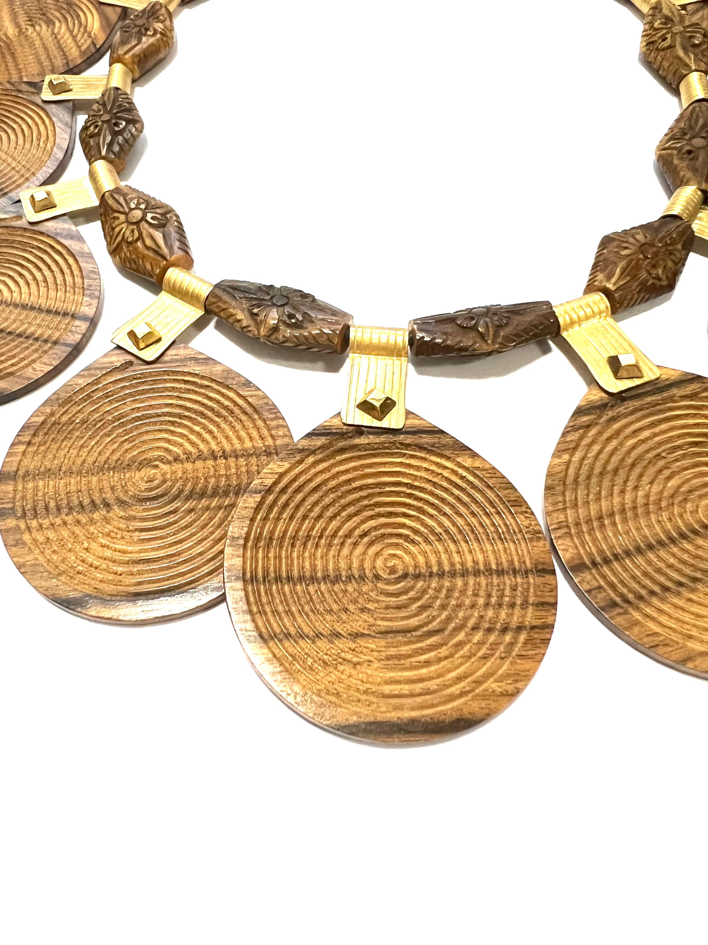 Ethnic Palissander And 18k Yellow Gold Necklace
This necklace is strung on black leather. 10 rosewood engraved interlayers alternate with 9 rosewood pendants hanging fron 18kt satin yellow gold engraved clips.
Total weight gr. 79
Gold weight gr.