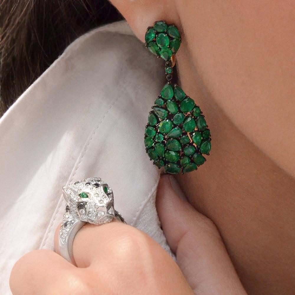 Set in 18-karat blackened gold, and fully articulated, this stunning pair of earrings are composed of 14.09 carats of rose-cut emeralds. The emeralds are of various weights in pear, round and oval cuts. The green emeralds set against the blackened