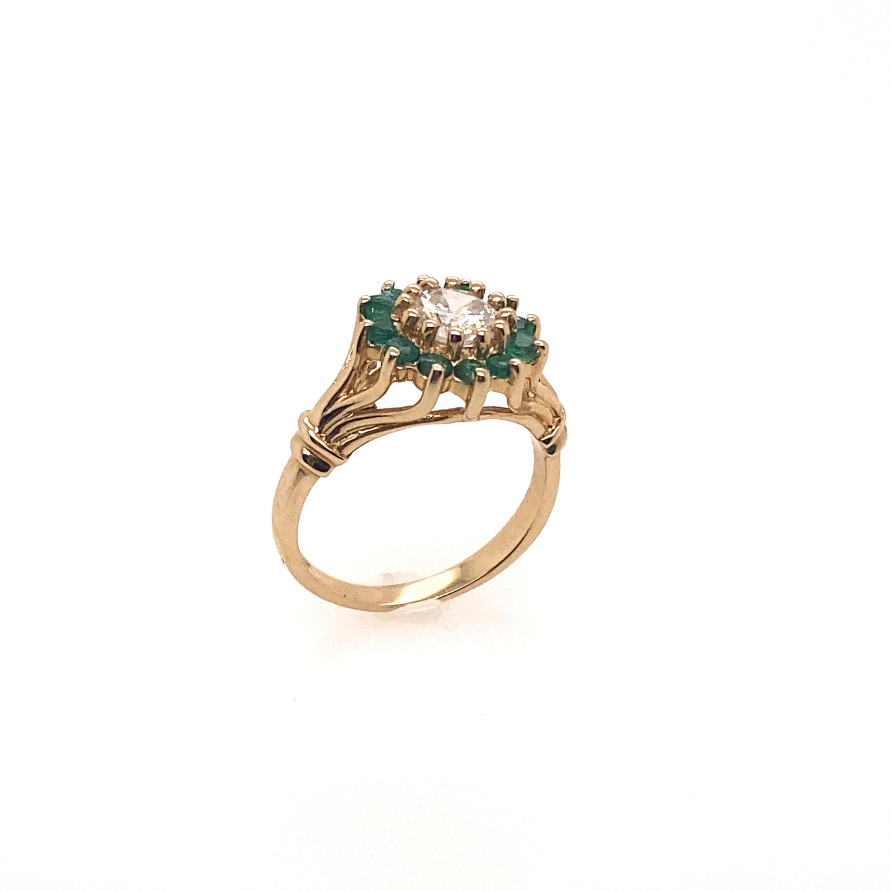 The center diamond 0.60 carat brilliant round set in the 14K yellow gold ring featured by a cluster design and surrounded by twelve round cut emerald. This ring features a very fashionable look and can be worn in everyday. 

Center Diamond Weight: