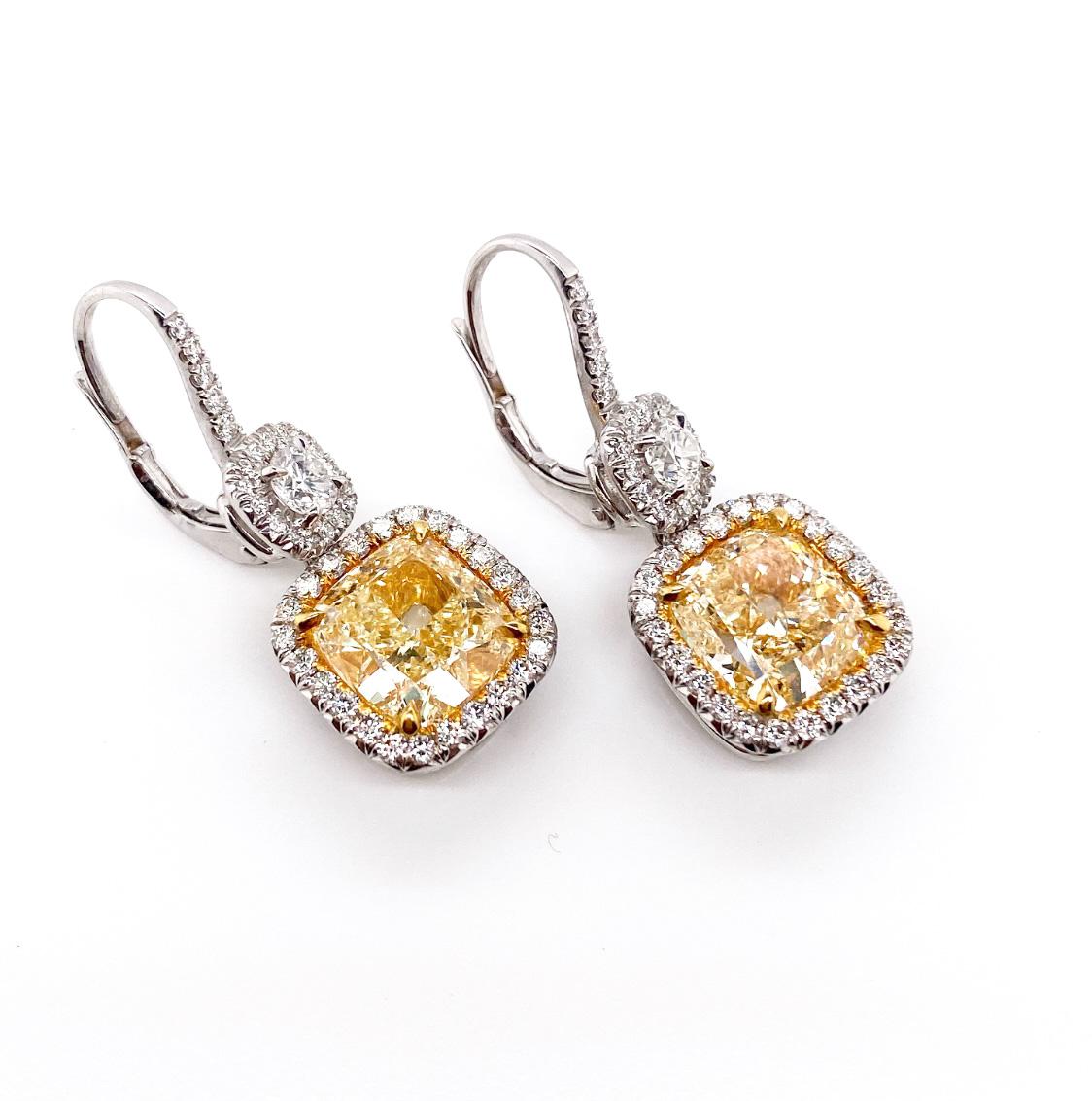 Make a glamorous statement with these timeless elegance dangle earrings. The very beautiful GIA certified yellow cushion diamonds perfectly framed with the sparkling white diamonds. In additional, 0.48 carat brilliant round diamond pair surrounded