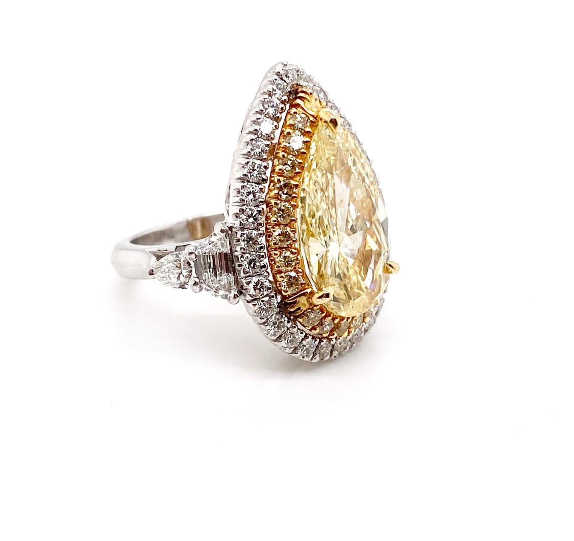 The rare Fancy Yellow pear cut 8.85 carat diamond set in 18K gold ring as a center stone surrounded by a halo of yellow round brilliant diamonds. In additional, another layer of a halo of white diamond framed and double-wrapped it again. The beyond