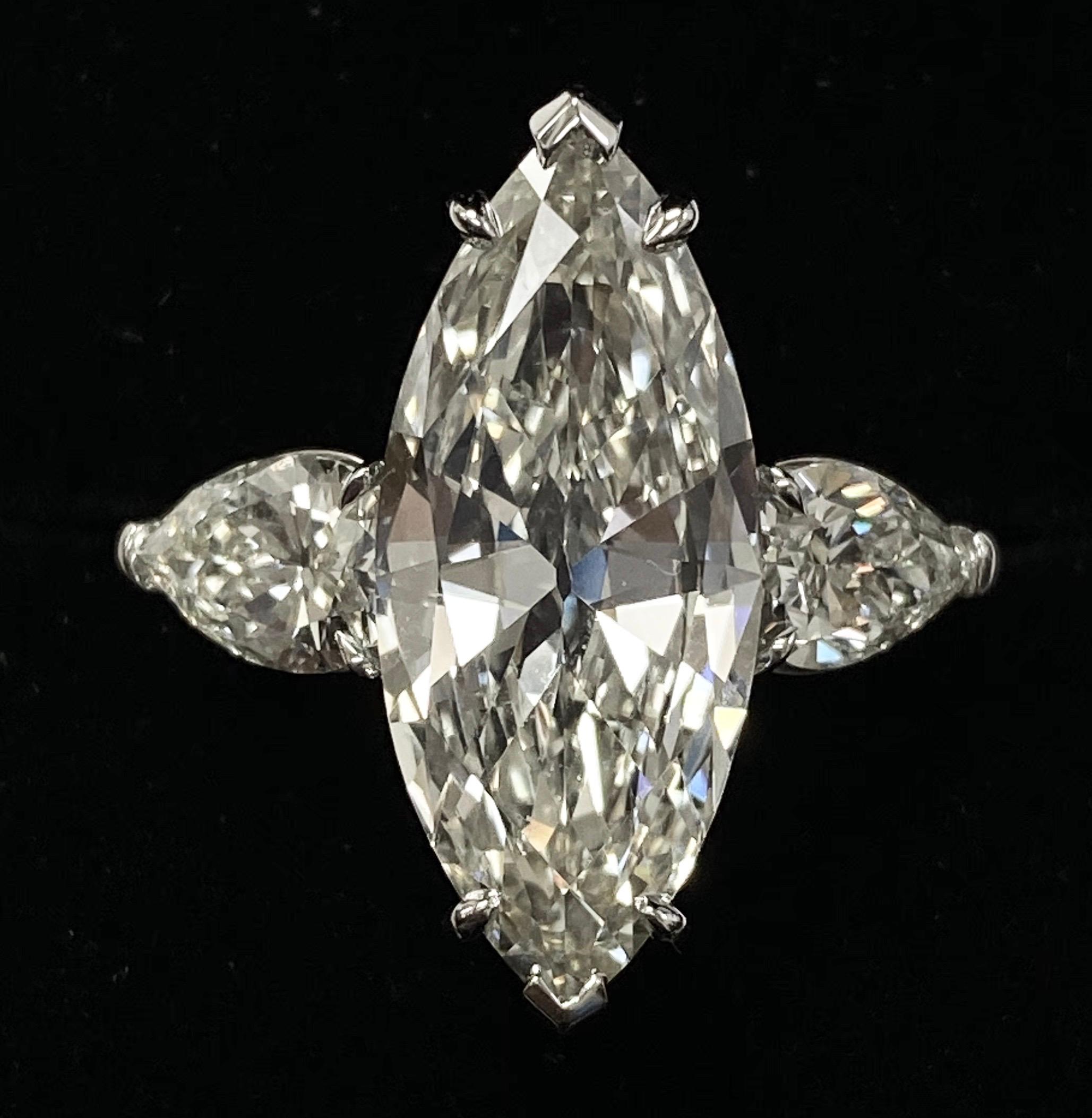 The rare size GIA Certified 4.61 carat marquise-cut diamond is perfectly accentuated with another two beautifully pear shape diamonds mounted on both sides of the 18K gold ring respectively. This stylish three-stone ring features big, bold and