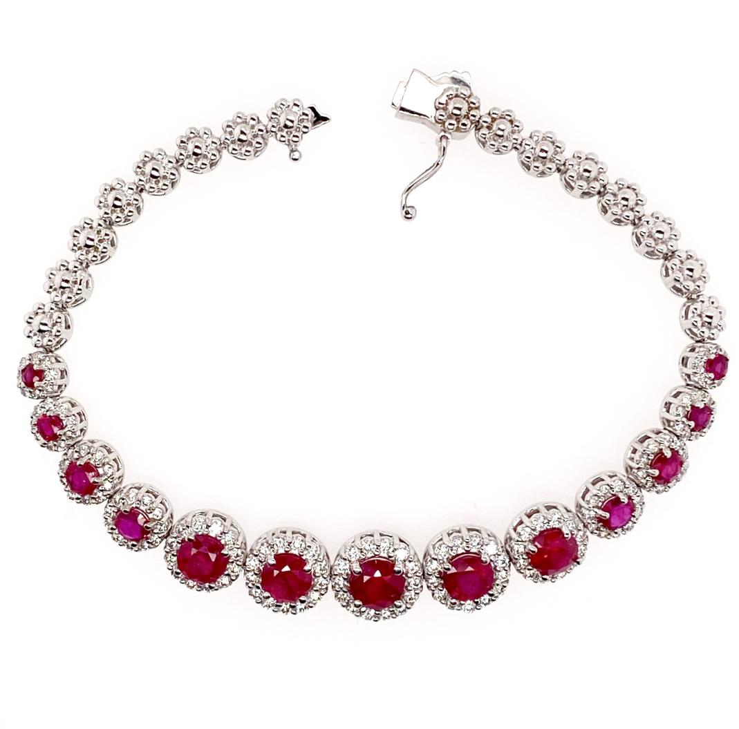 This bracelet features a deep reddish, round faceted ruby surrounded by a halo of round brilliant-cut diamonds set in 18K white gold. It is consisting of thirteen graduating ruby and diamond clusters. The matching earrings and necklace are available