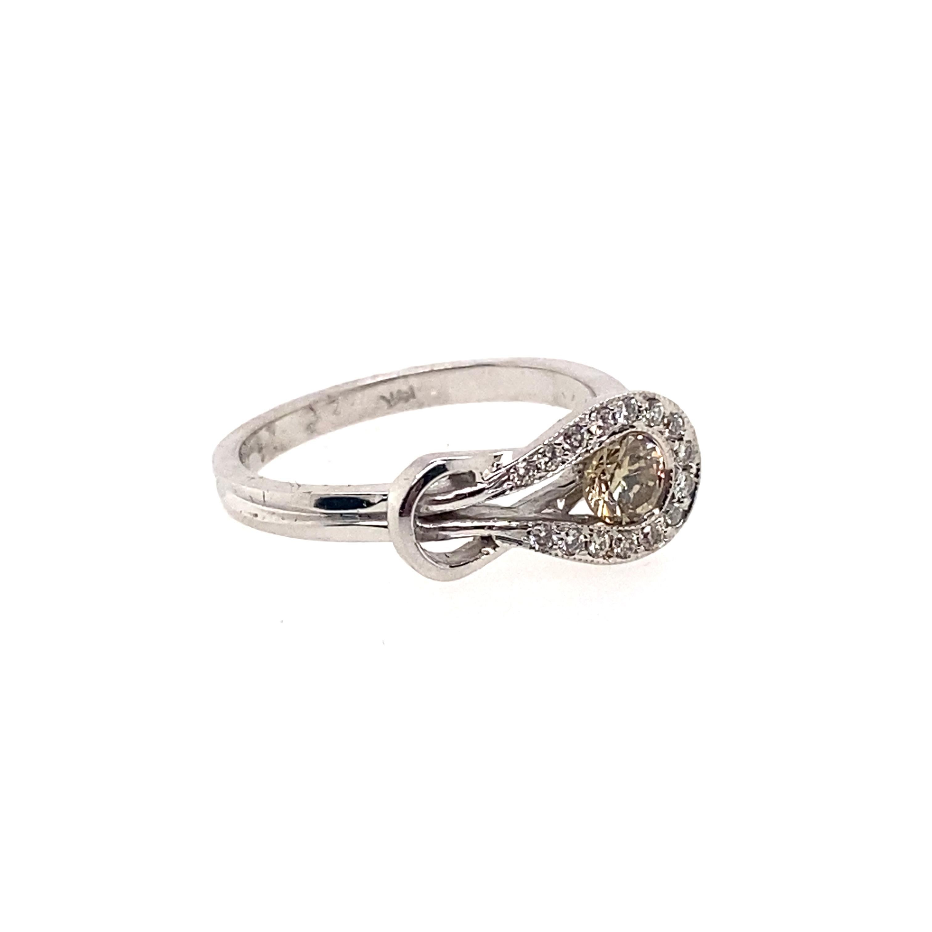 This unusual diamond ring design features 0.28 carat round brilliant cut brown diamond within a tilted loop bezel setting. The side diamonds are set in the loop. This simple yet contemporary design which will provide you with both comfort and
