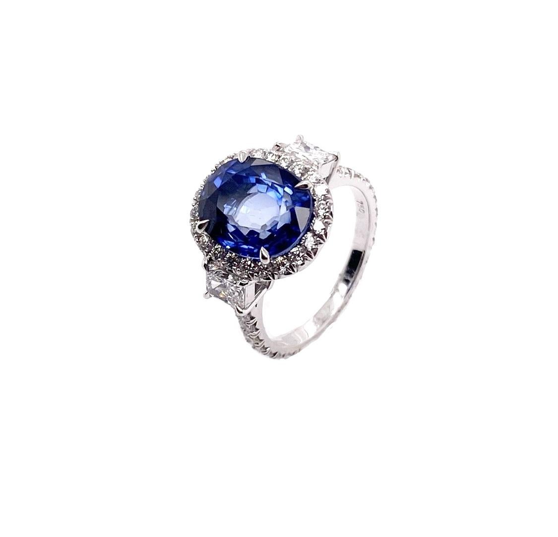 This unique and luxurious ring makes a statement with 5.92 carat oval shaped blue sapphire that is complemented by the brilliant round cut diamonds in an oval halo fashion. The blue colored gemstone and diamonds set on a remarkably stunning in 18K