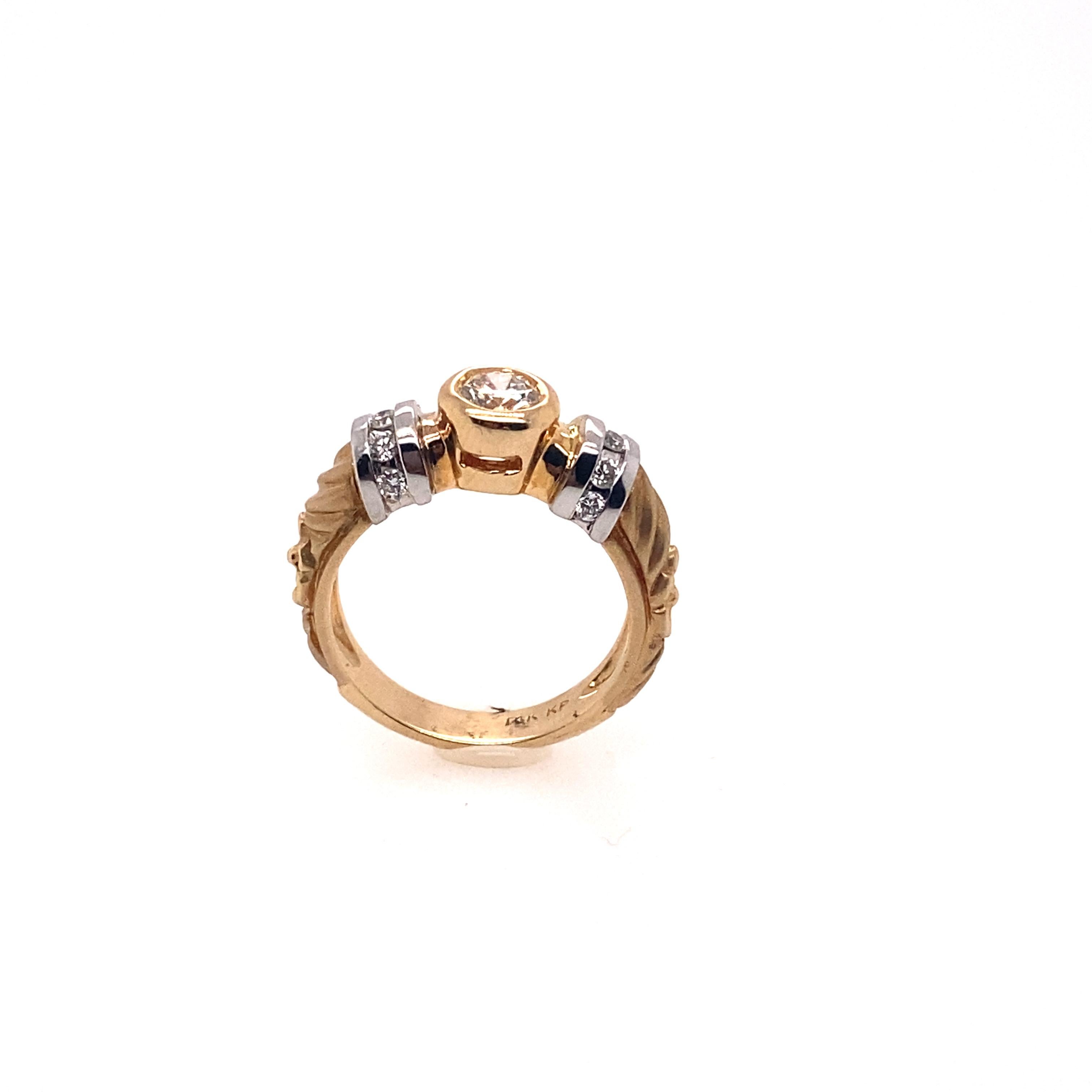 The whole shank of the ring is hand-engraved art and the shoulder of the ring is coated by the white gold and side diamonds. 0.72 carat round diamond is mounted as a center stone and this two-tone gold ring is very unique and classy. 

Center