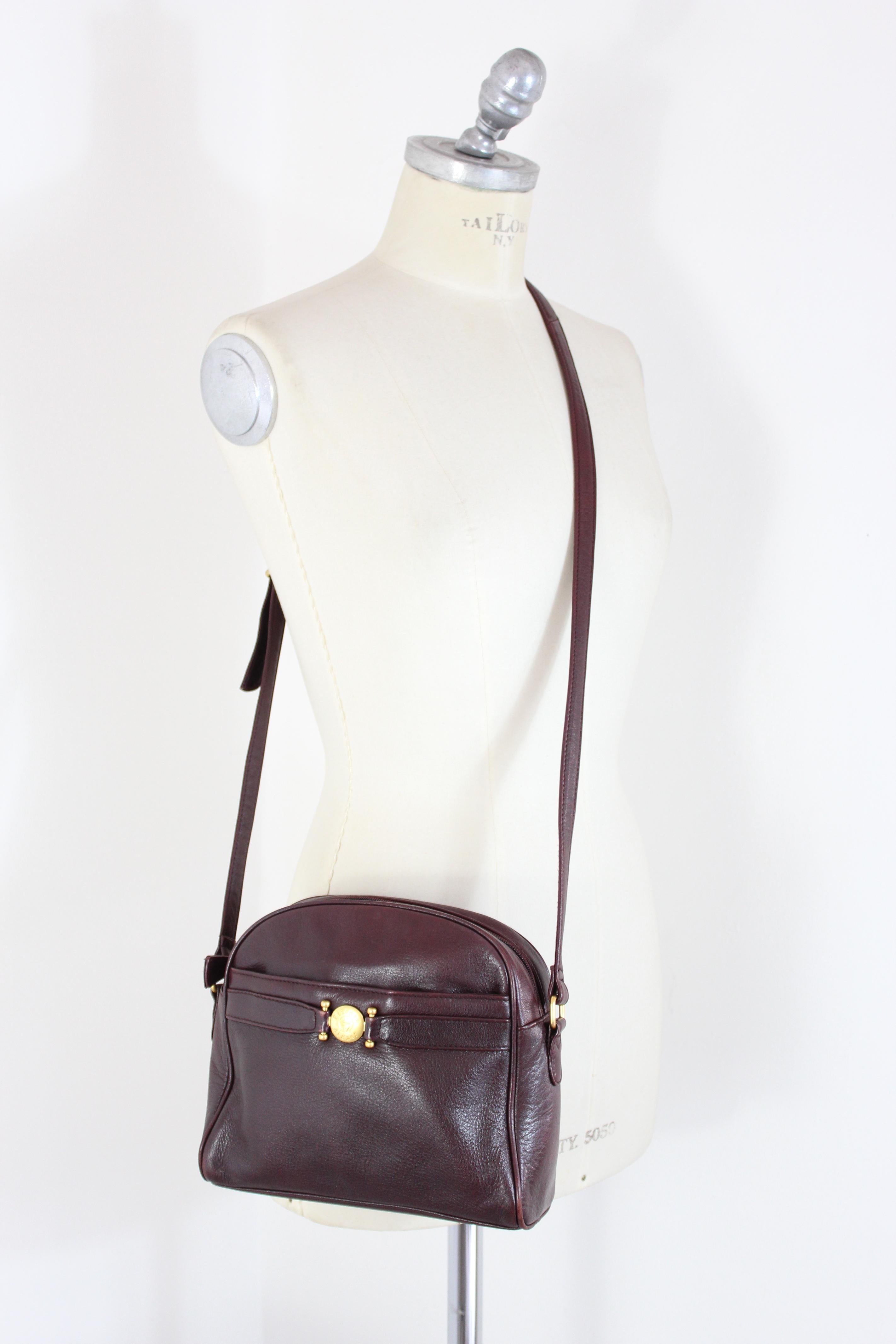 Etienne Aigner vintage 80s bag. Shoulder bag, burgundy color with gold details. Adjustable shoulder strap, external and internal compartments, zip closure. 100% leather fabric. Made in France. Very good vintage condition, some small signs of wear