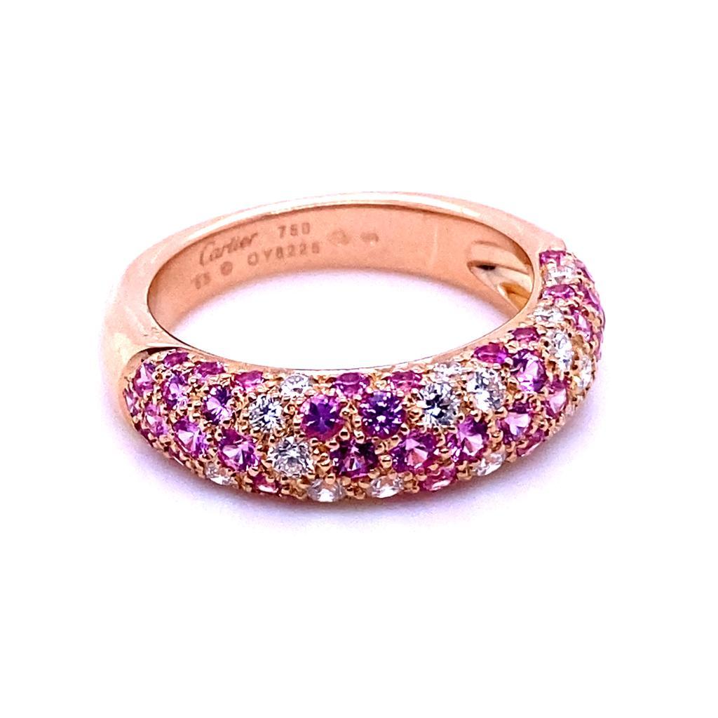 An Etincelle De Cartier pink sapphire and diamond ring in 18 karat rose gold.

Composed of pavé set pink sapphires and round brilliant cut diamonds alternating in placement half set across the gently curved plain polished rose gold band. The