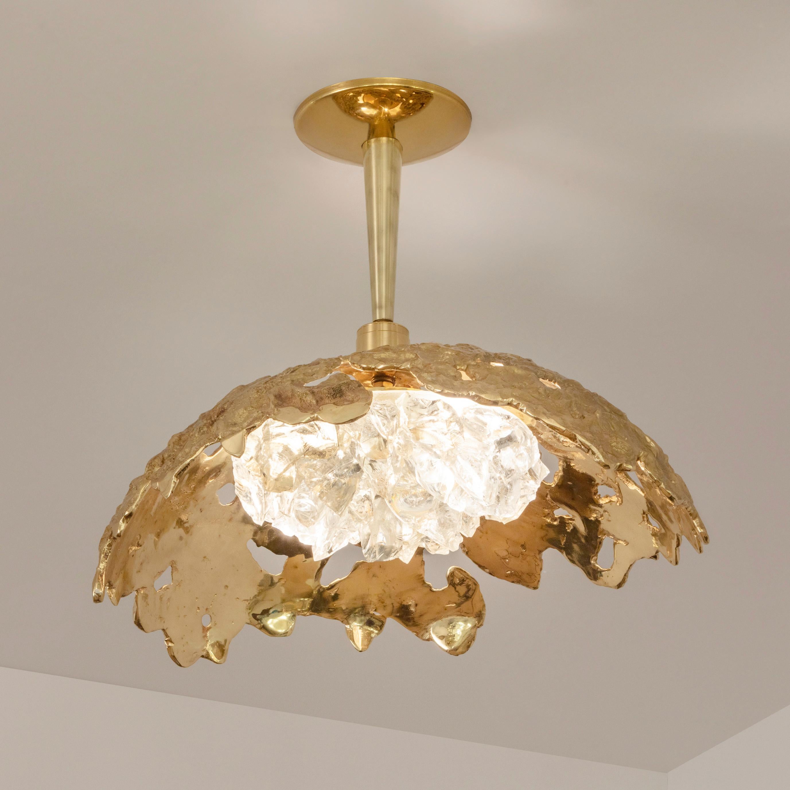 Blending sculpture and design, the N.15 is the intermediate fixture of the Etna series with a glass shade composed of dozens of crystal elements. The organic cast brass shell culminates in a polished stem and canopy. The first images show the