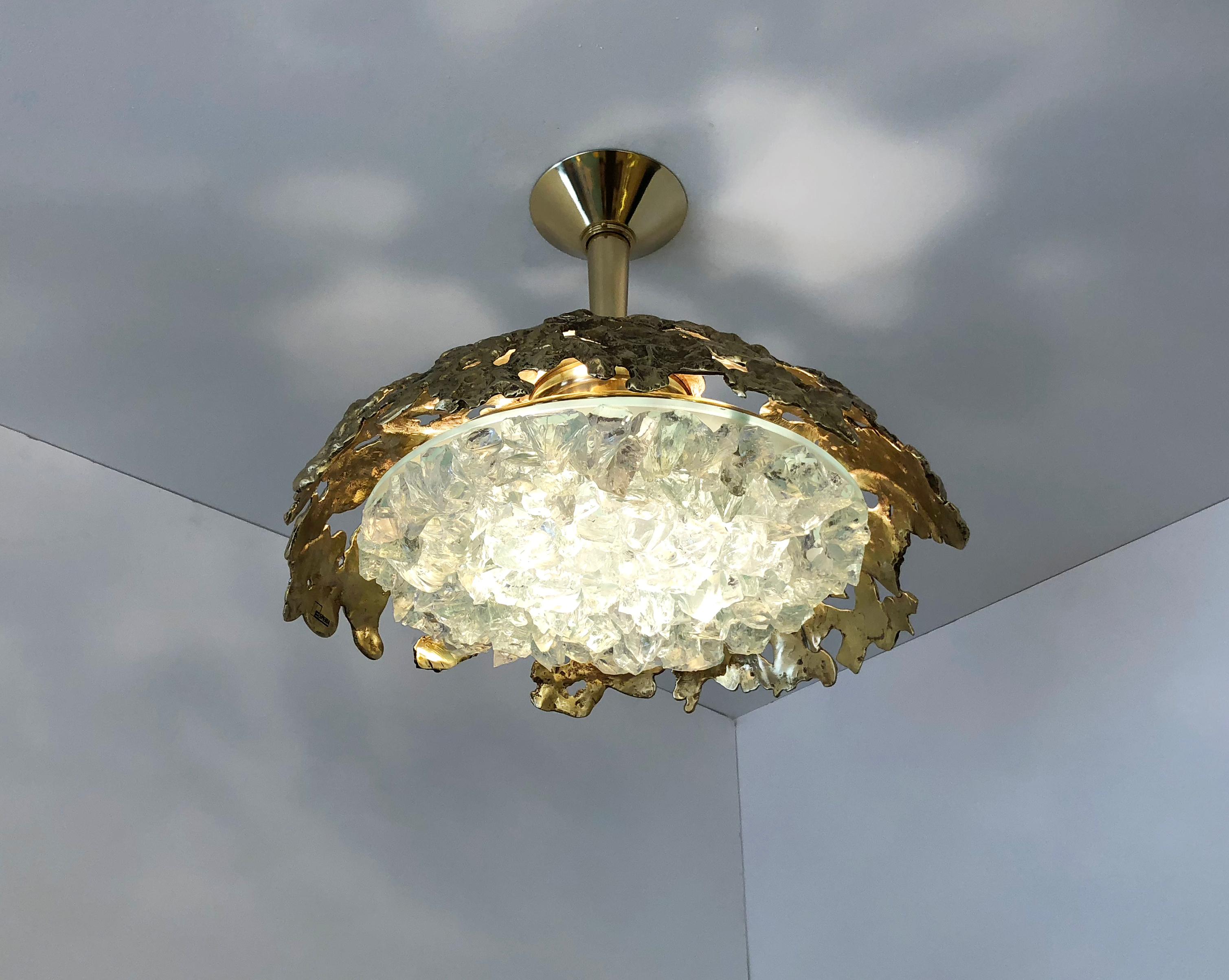 Blending sculpture and design, the N.21 is the largest fixture of the Etna series with an expansive glass shade composed of dozens of crystal elements. The organic cast brass shell culminates in a polished stem and canopy. Shown in polished brass