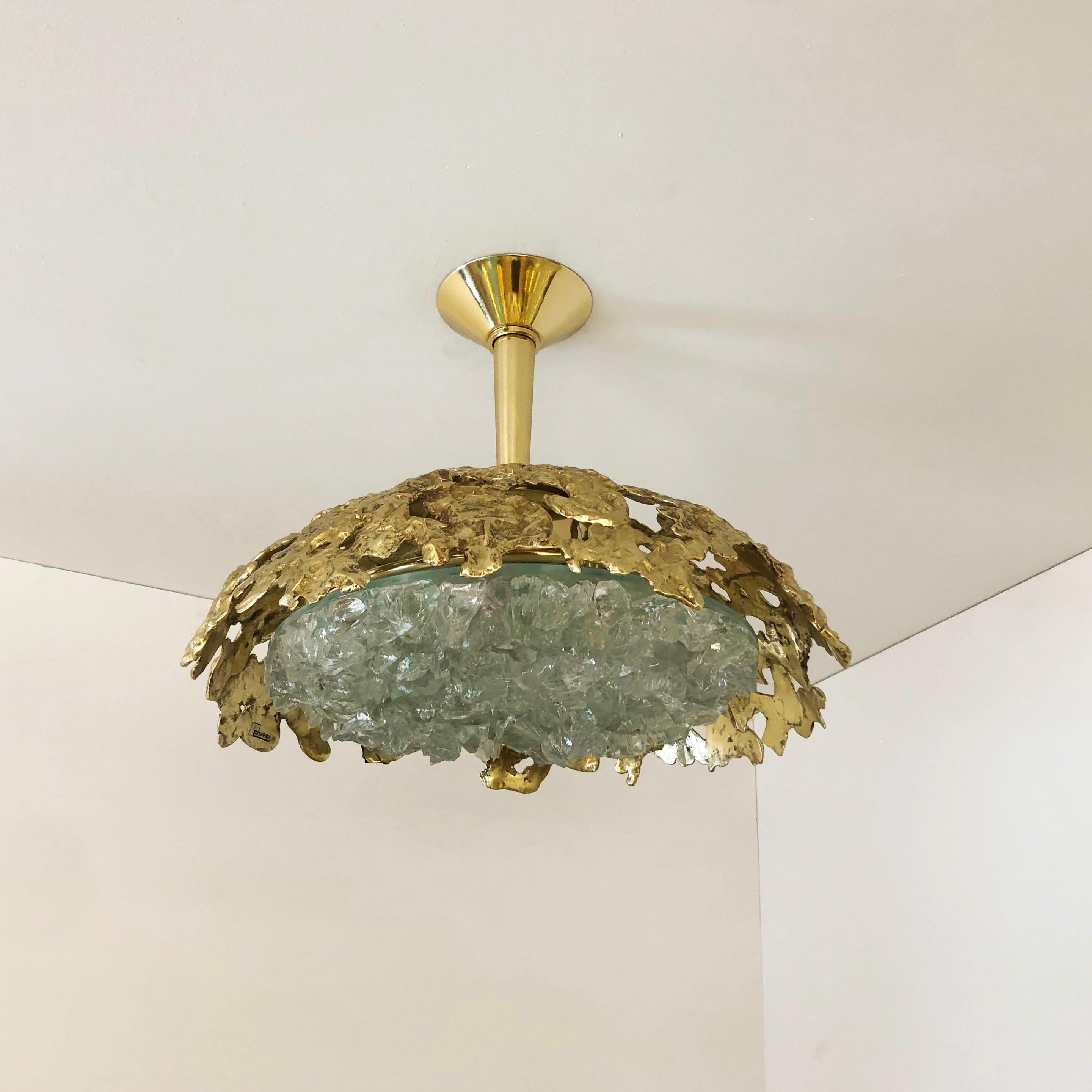 Blending sculpture and design, the N.21 is the largest fixture of the Etna series with an expansive glass shade composed of dozens of crystal elements. The organic cast brass shell culminates in a polished stem and canopy. Shown in polished brass